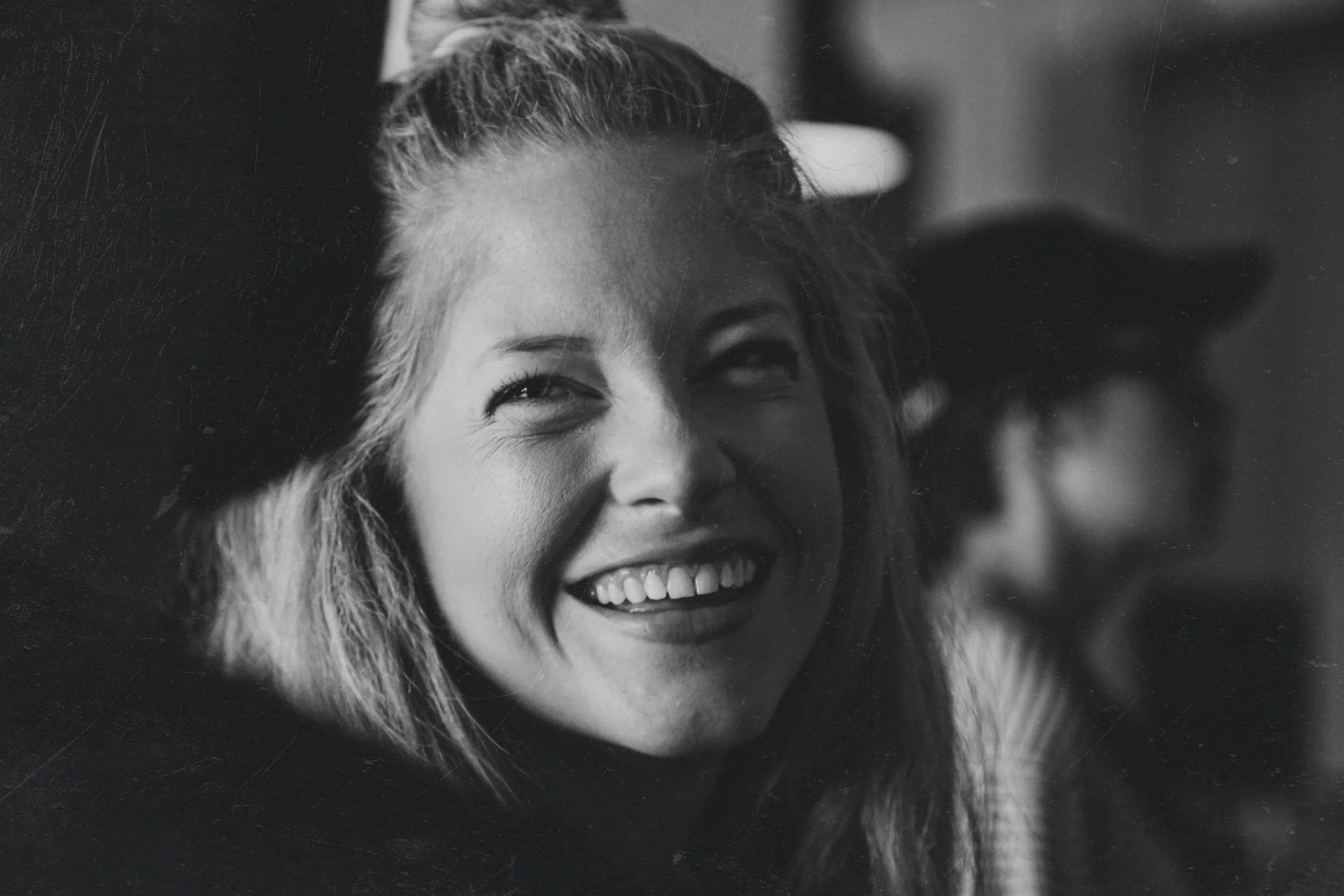 Black and white photo of a woman smiling and looking slightly to her right.