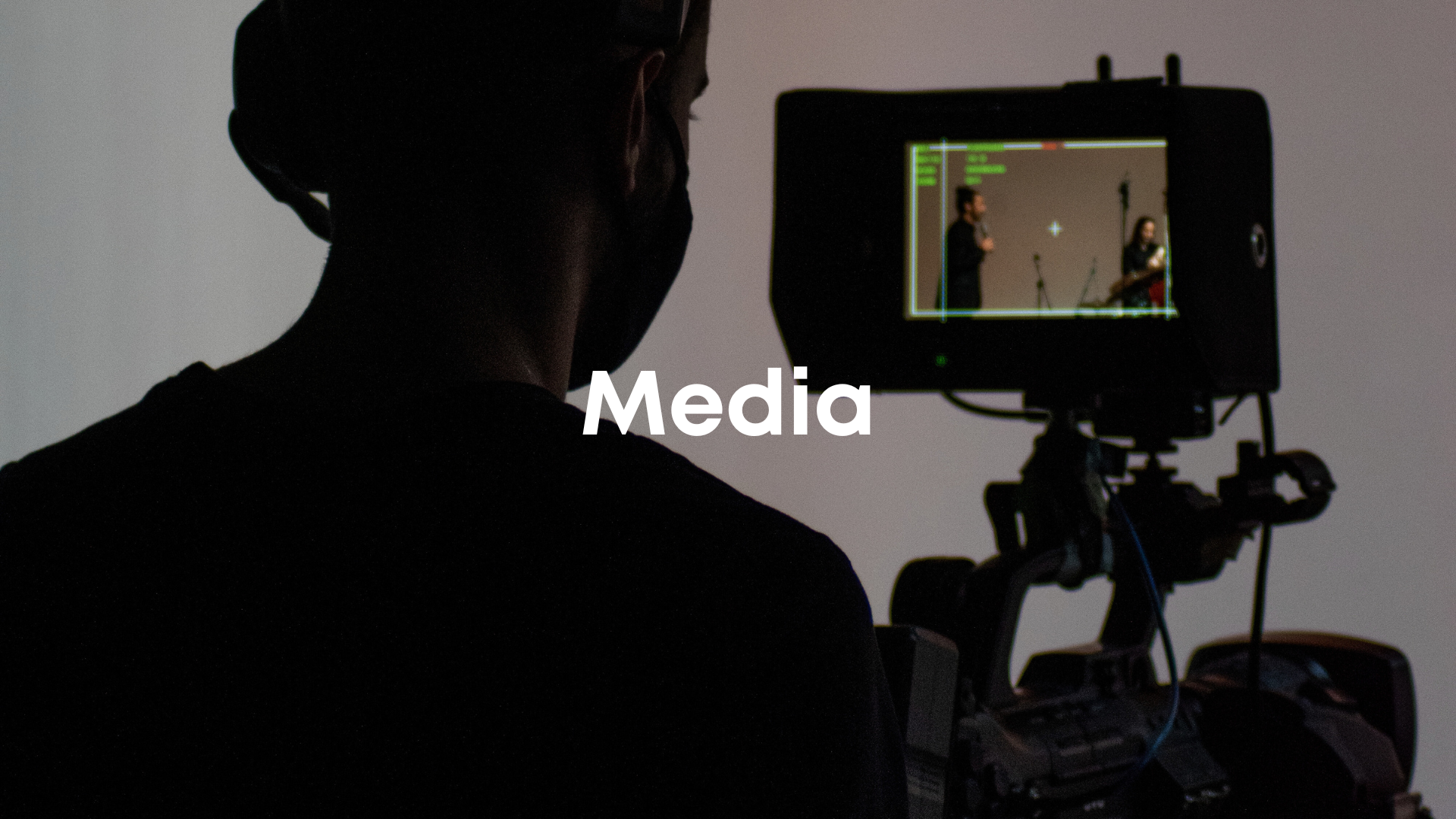 Person filming a video or photograph with a professional camera in a studio setting.