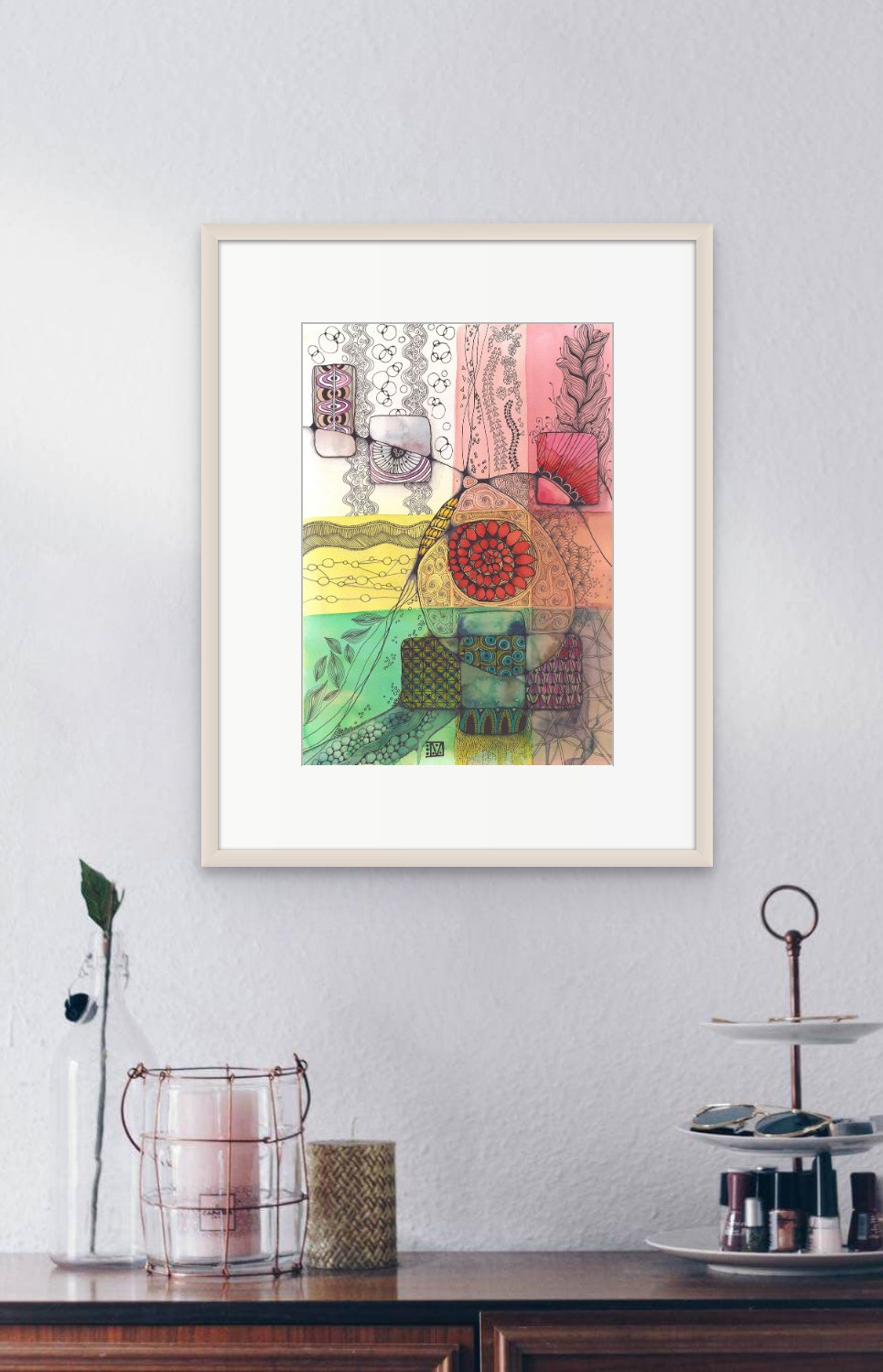 Framed with light wood under glass and mount on a light grey wall with a buffet bellow it sporting a cakestand