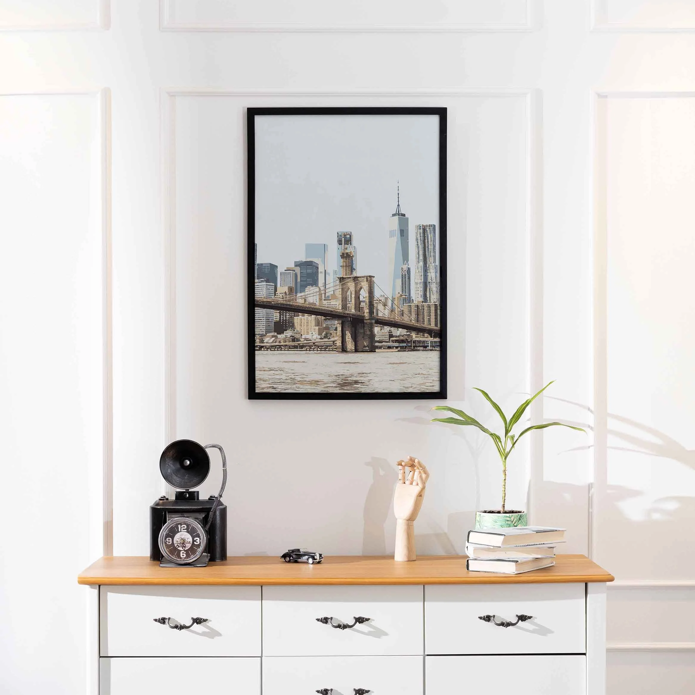 A poster featuring the Brooklyn Bridge hung on a white wall.a