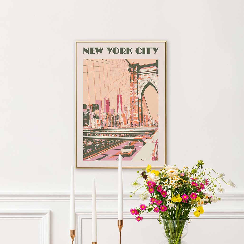 Framed New York City poster in orange tints next to a bouquet of flowers.