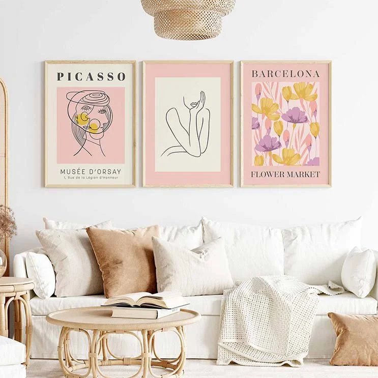 Three art prints in shades of pink, hung on a white wall.