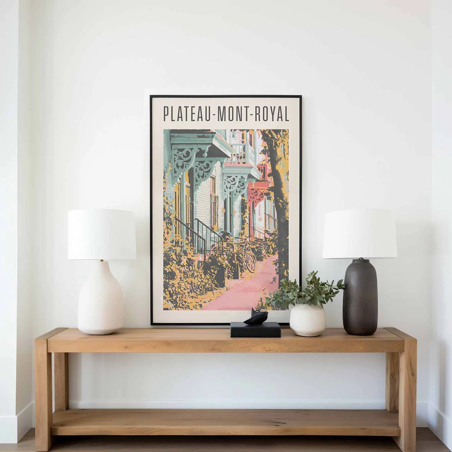 A Plateau poster on a coffee table flanked by two table lamps.