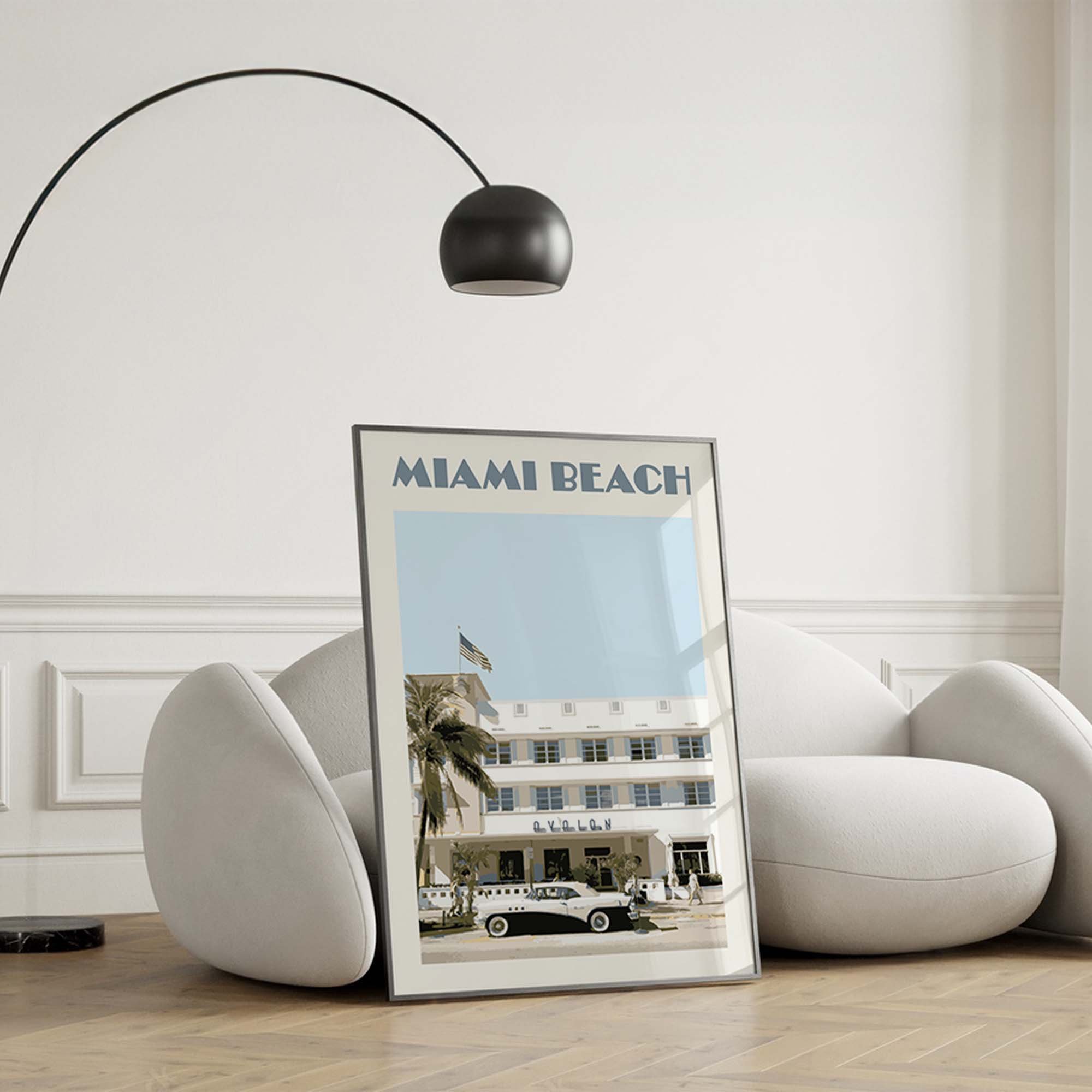 A Miami Beach poster standing against a modern sofa.
