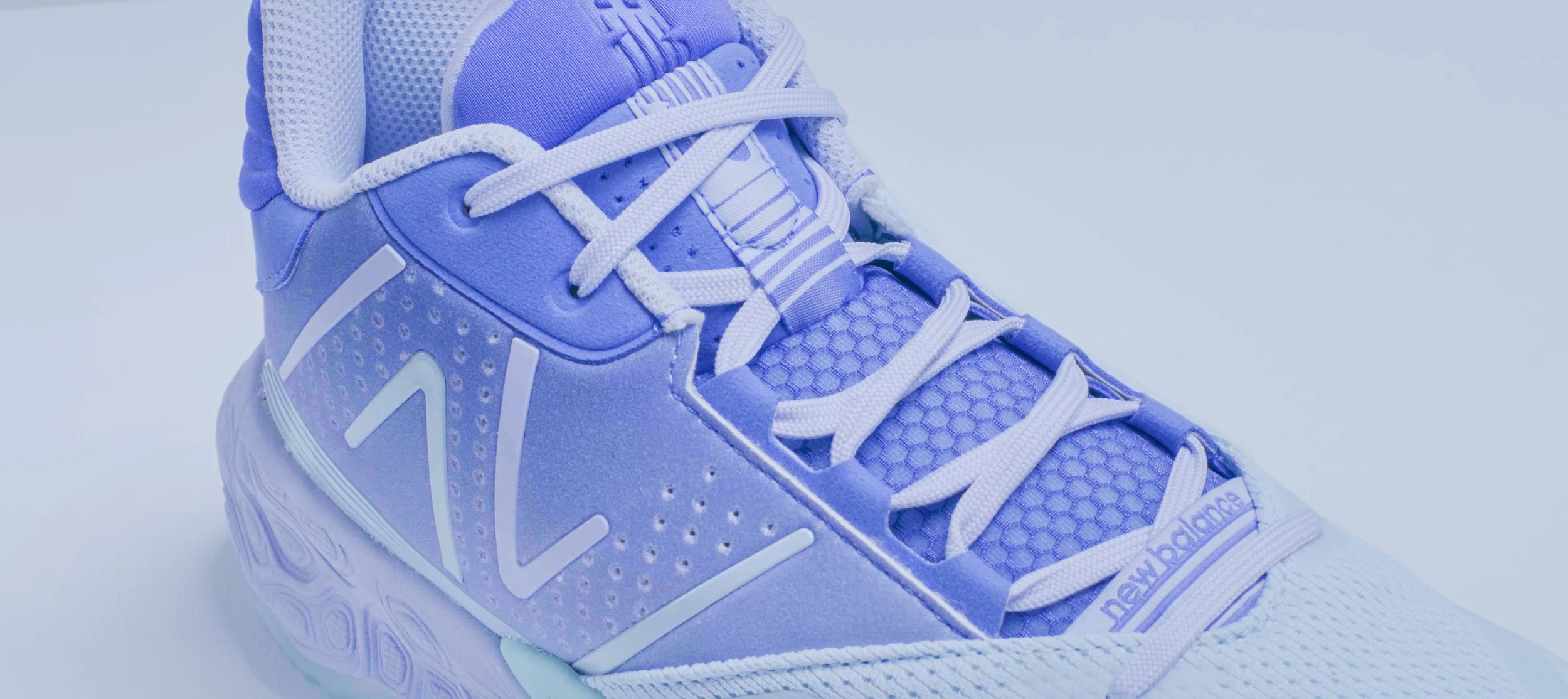 Close-up of a purple athletic sneaker with white laces and accents, featuring the New Balance logo.