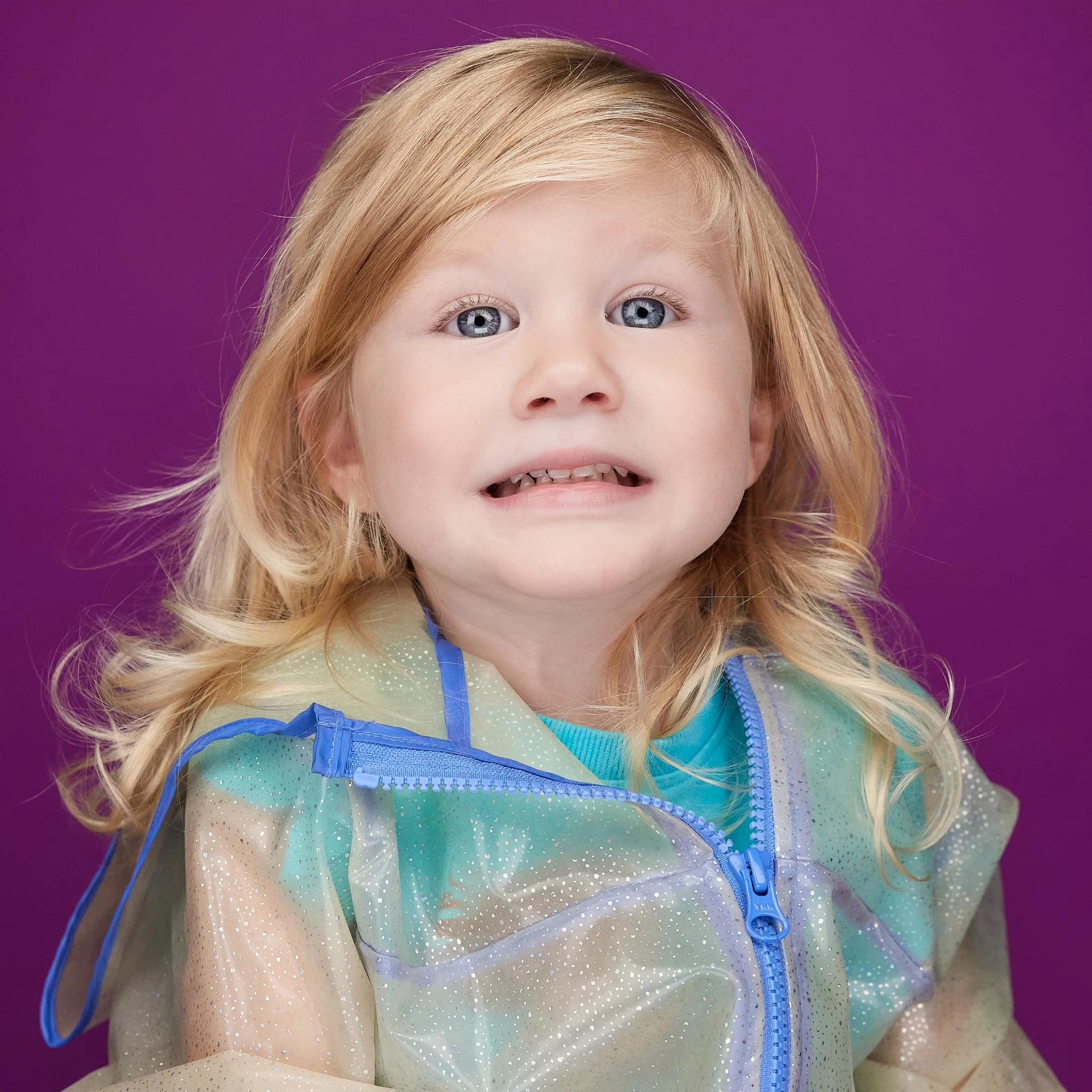silly cheese smile toddler girl in raincoat 