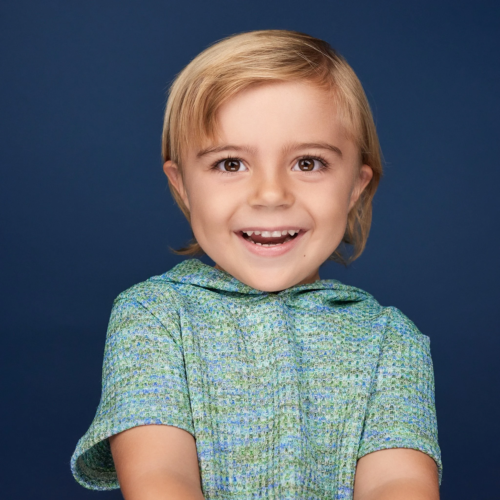 toddler big smile on blue backdrop