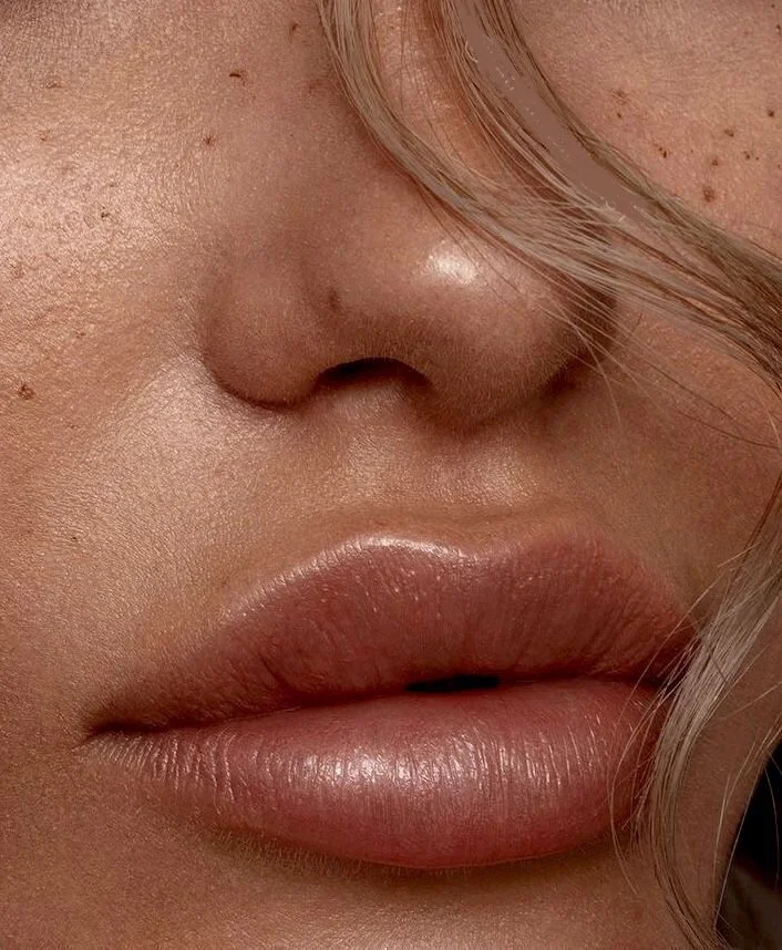 Close-up of a woman's lips and nose, showing smooth skin and natural lip color.