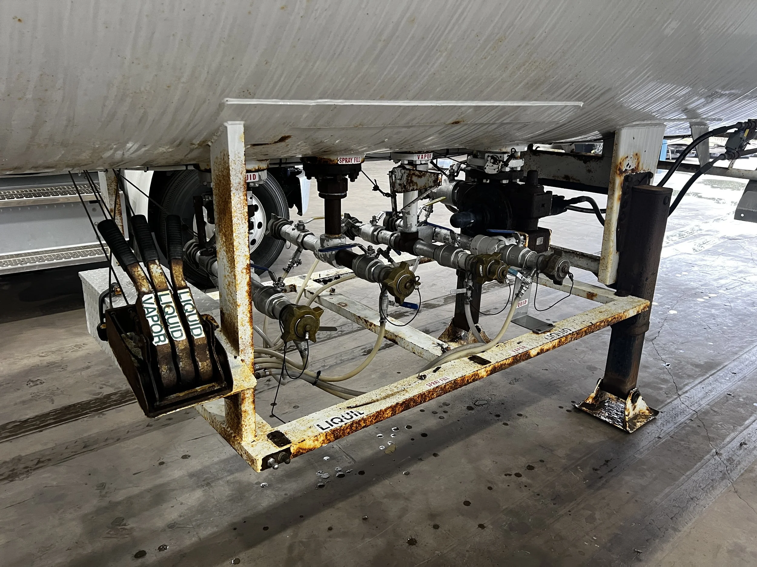 Underwater fuel spray system on a boat, showing rusted metal frame with multiple pipes, valves, and labels reading 'LIQUID FUEL' and 'SPRAY FILL'.