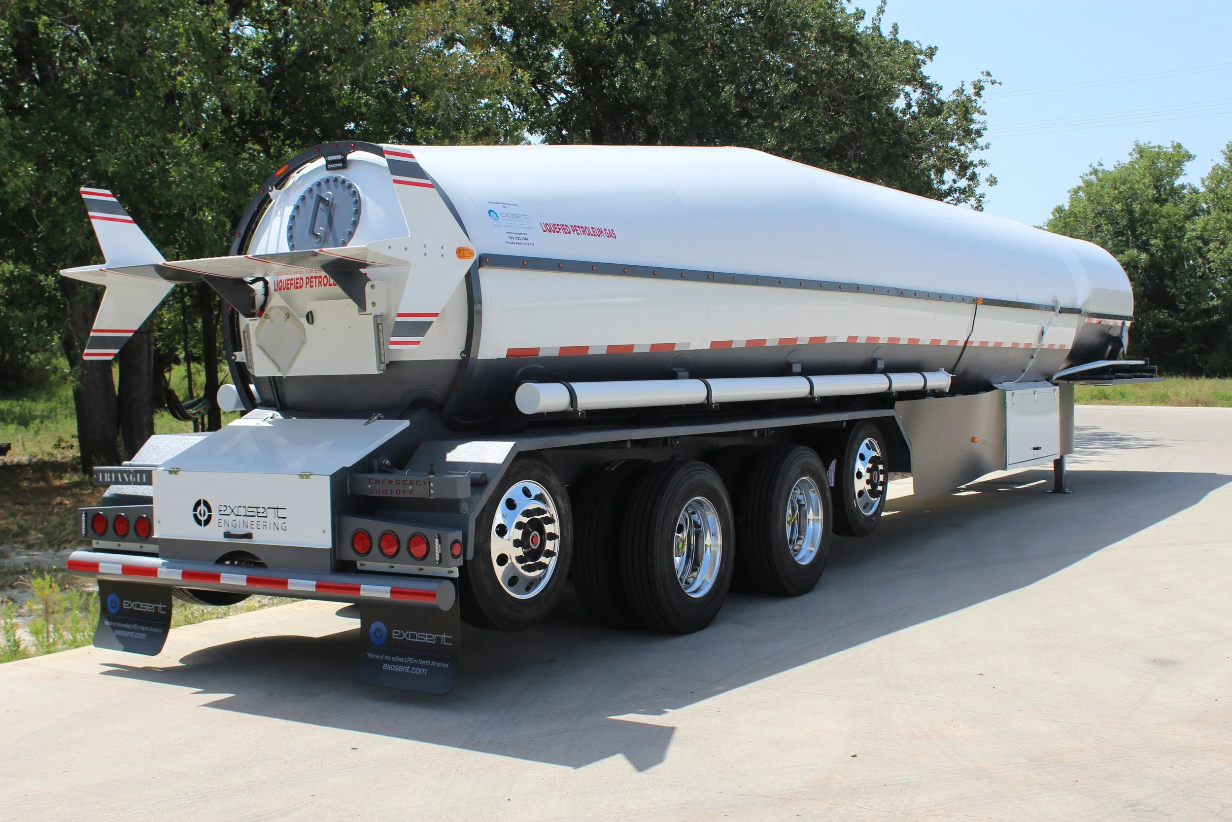 A large fuel tanker trailer on a concrete surface, labeled for liquefied petroleum gas with multiple wheels and a shiny metallic finish.