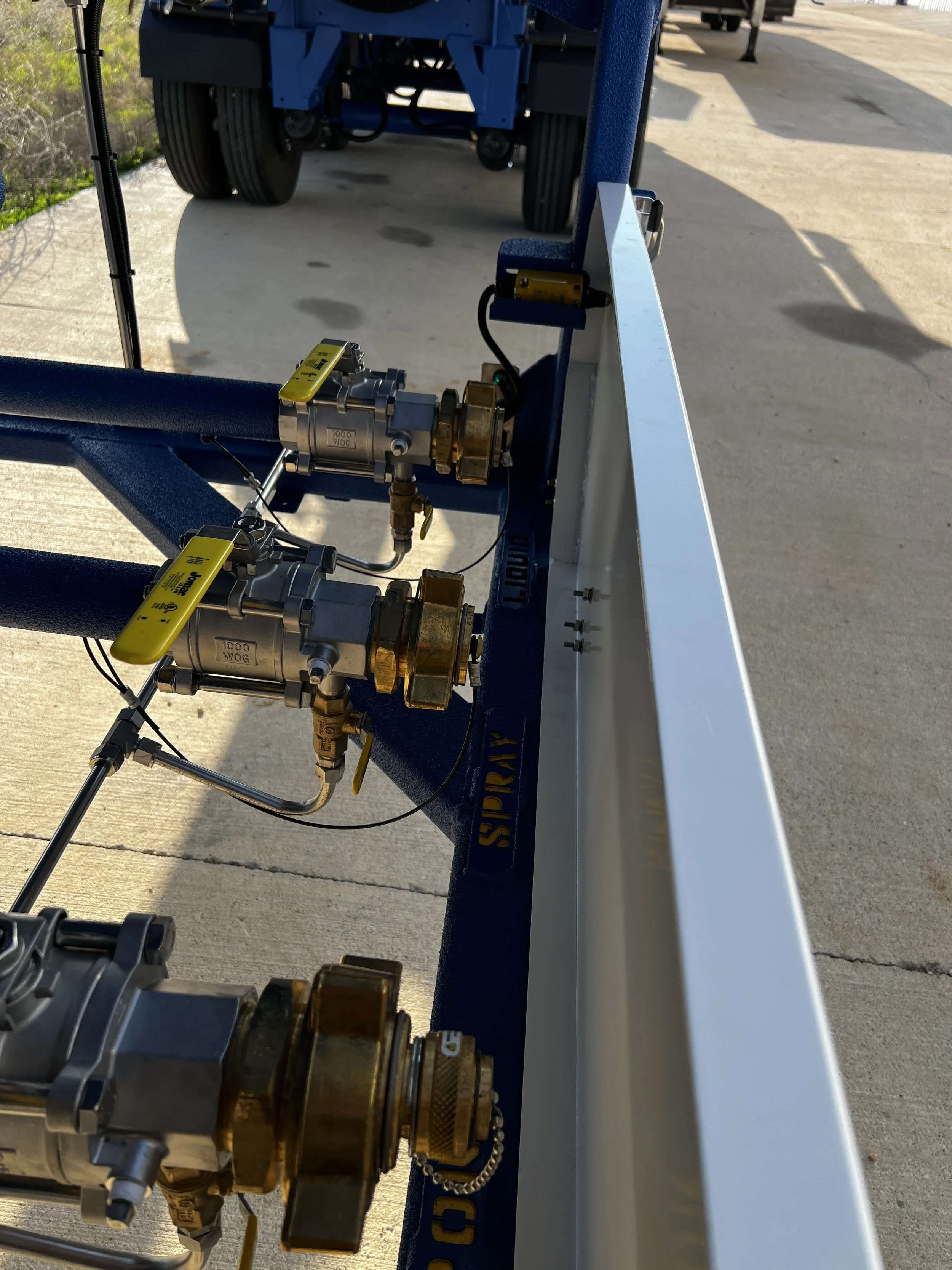 Industrial equipment with brass valves, pressure gauges, and labels, mounted on a blue metal frame labeled 'SPIREX'.