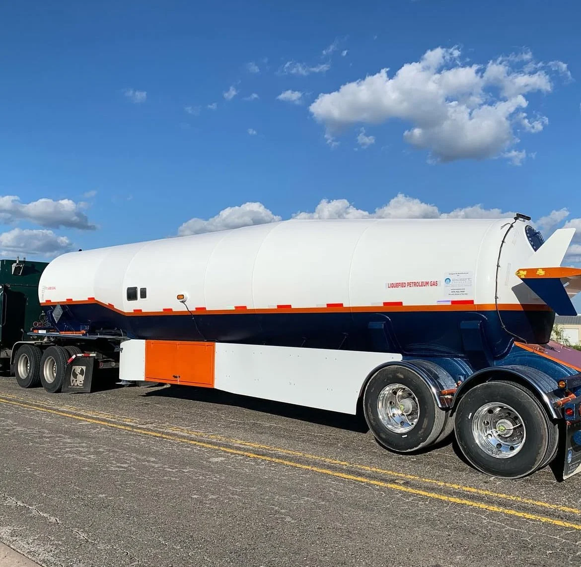 A tanker truck labeled 'Loubfied Petroleum Gas' parked on a road under a partly cloudy sky.