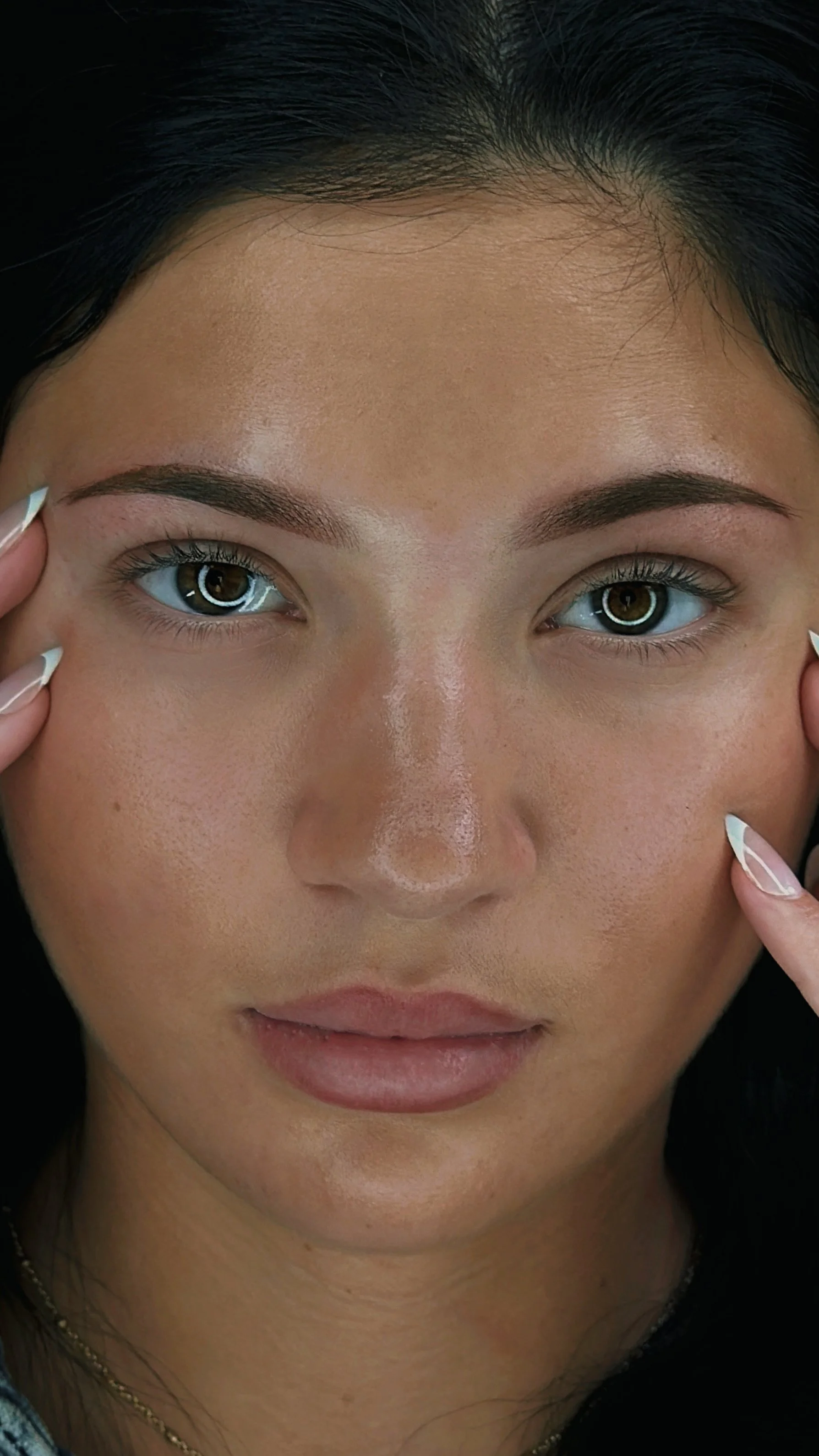 headshot of a client after her cosmetic tattoo appointment showing her fresh, natural looking powder brows