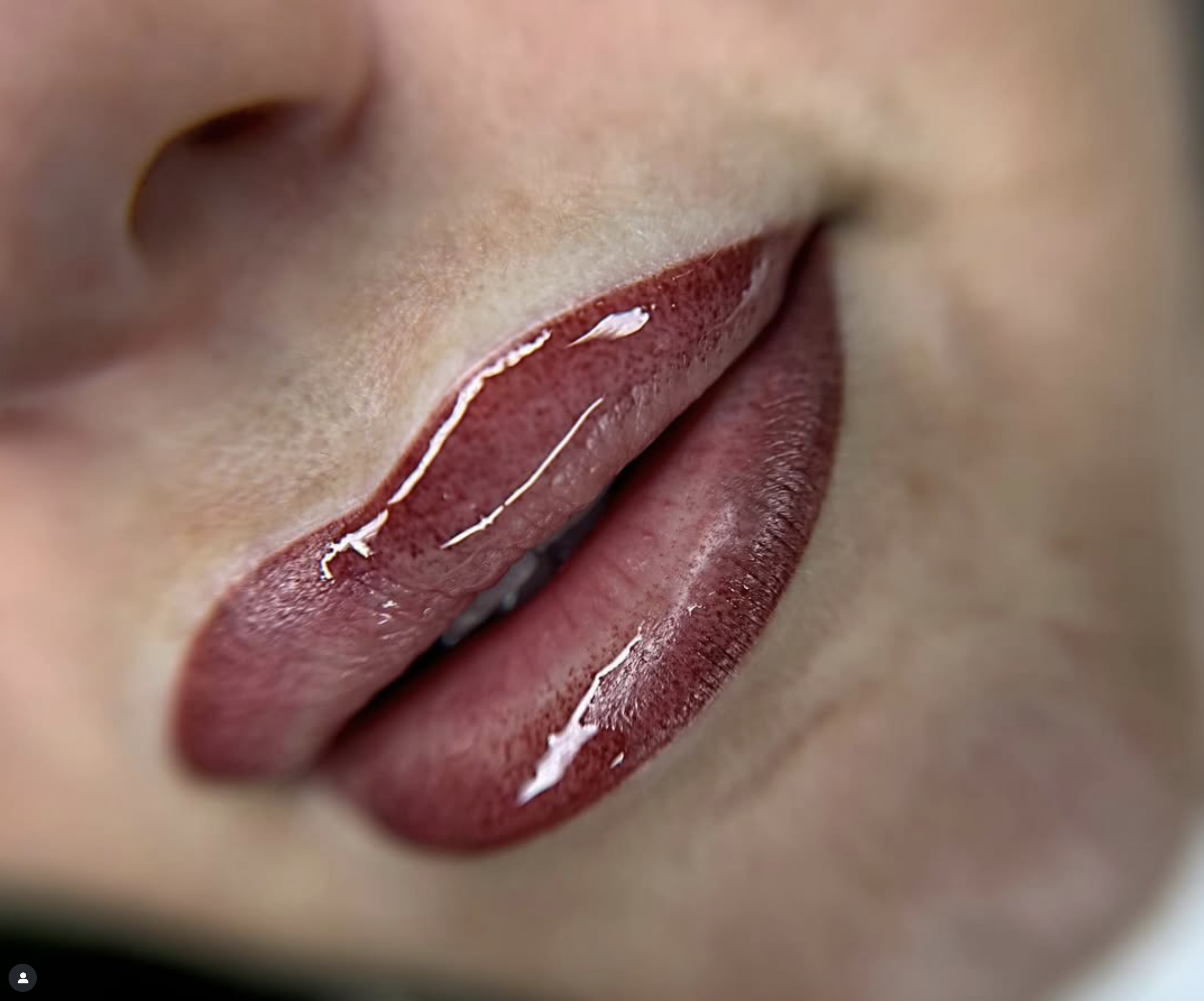 closeup photo of fresh glossy lip blushing in a rich berry pigment