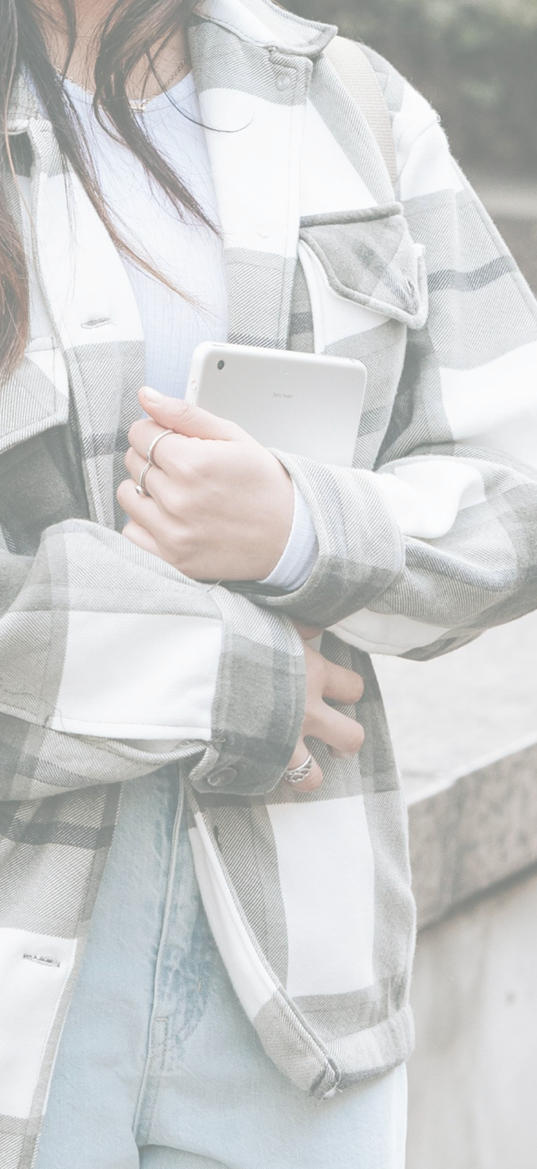 A person wearing a gray and white plaid jacket holding a white Sony Xperia smartphone.