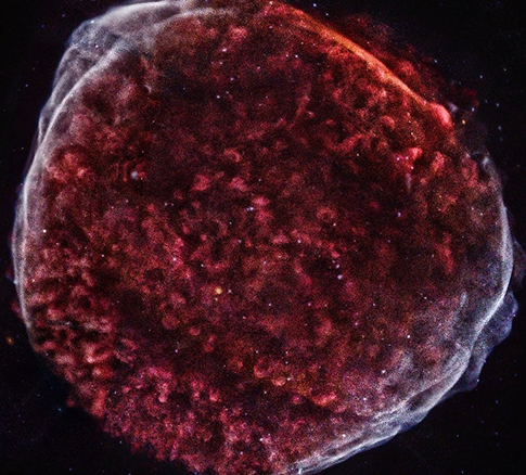 Close-up of a red and purple planet-like celestial body in space.