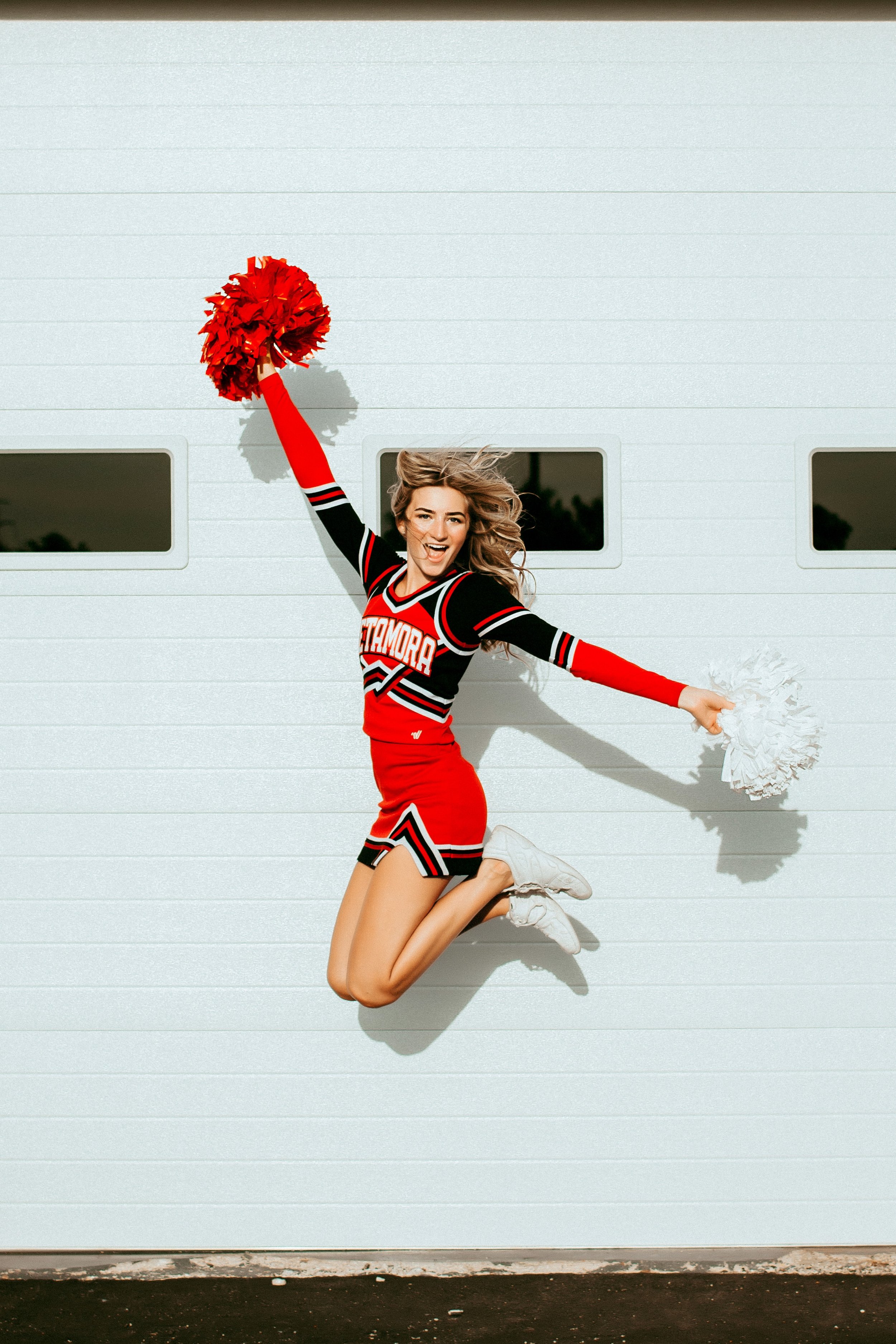 cheerleader jumping with pom poms