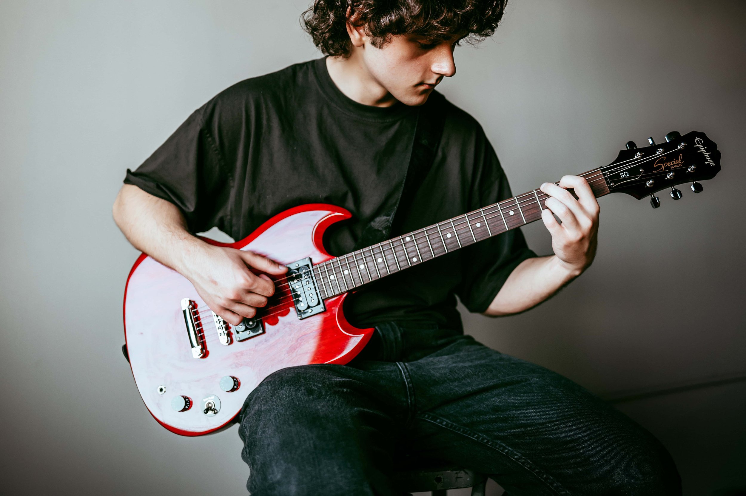 high school senior playing guitar during pictures in syracuse