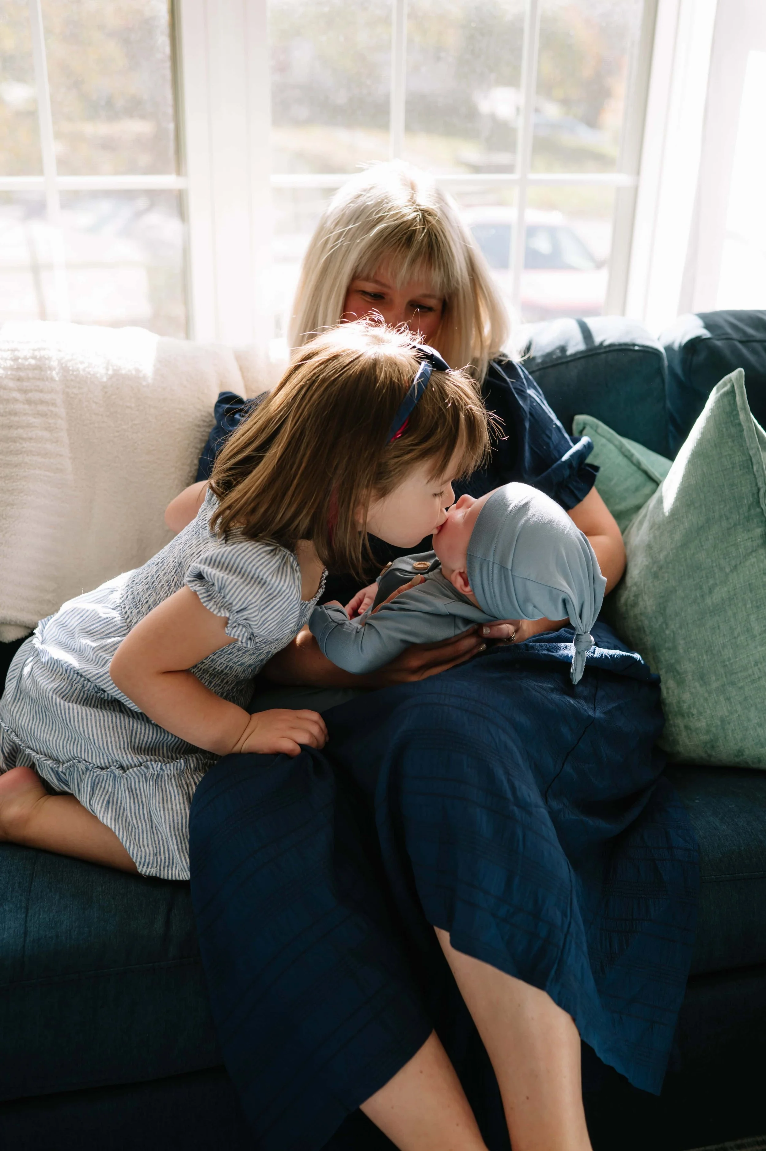mom holding newborn and toddler