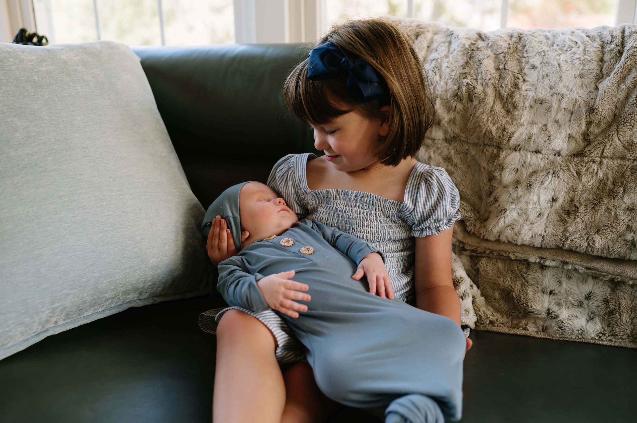 older sister holding newborn baby boy