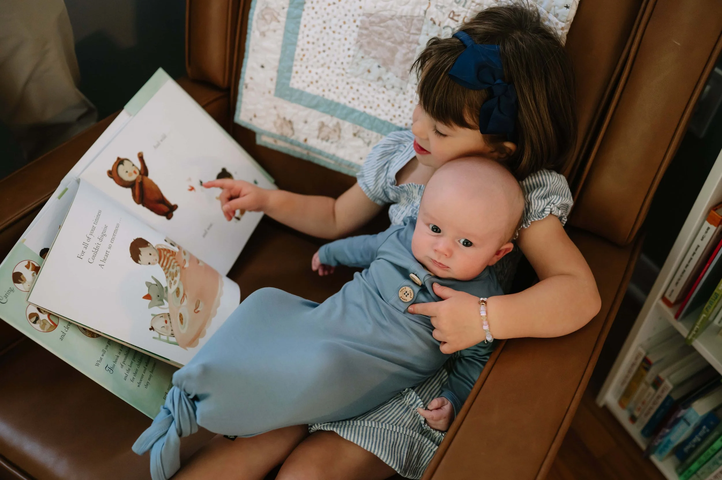 older sister holding newborn baby during photography session