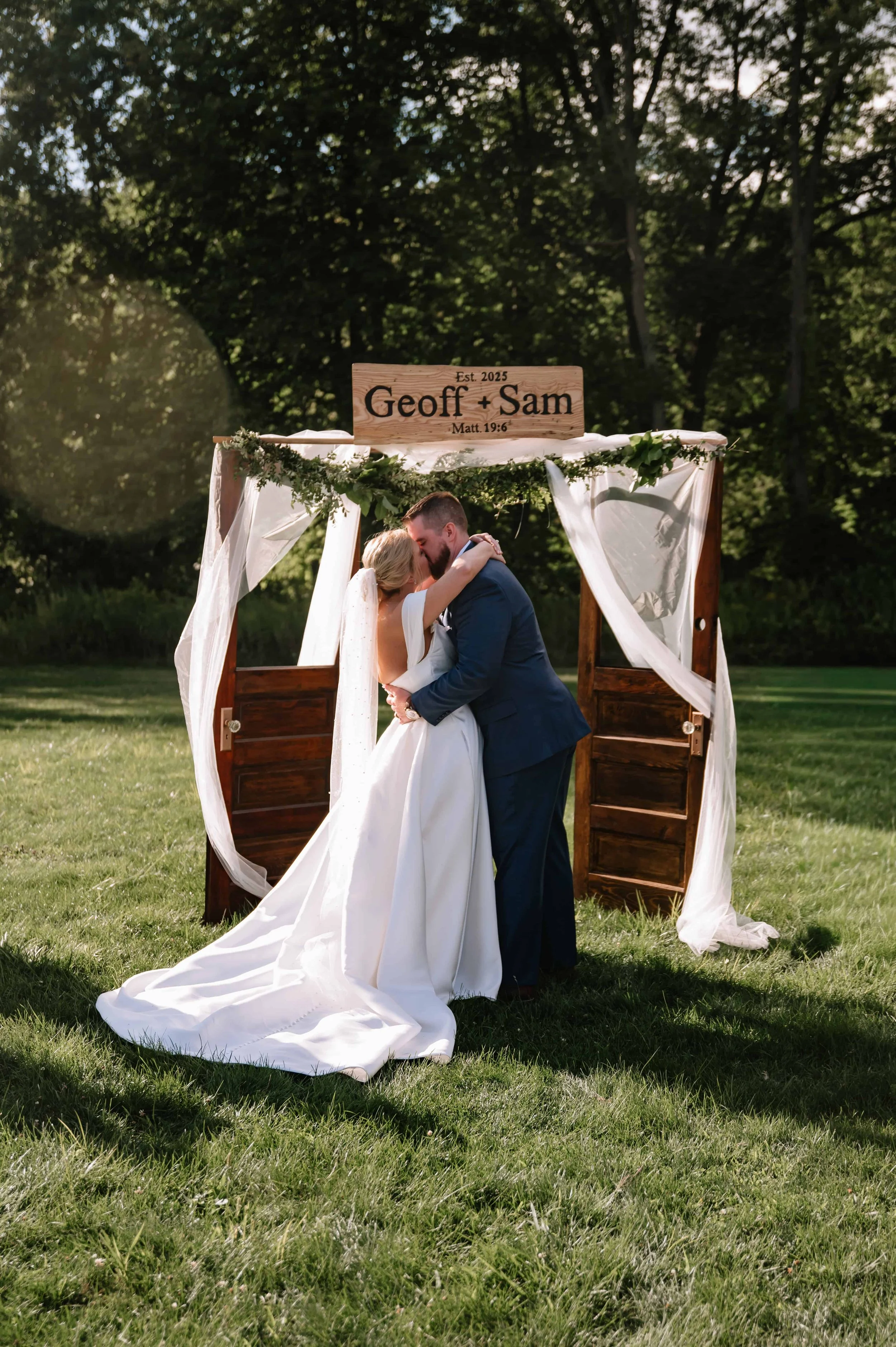 bride and groom first kiss during outdoor ceremony