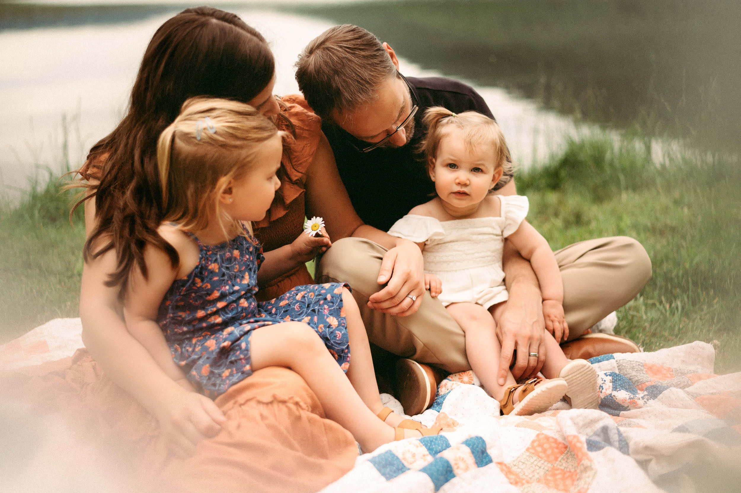 family of four sitting on a blanket.jpg