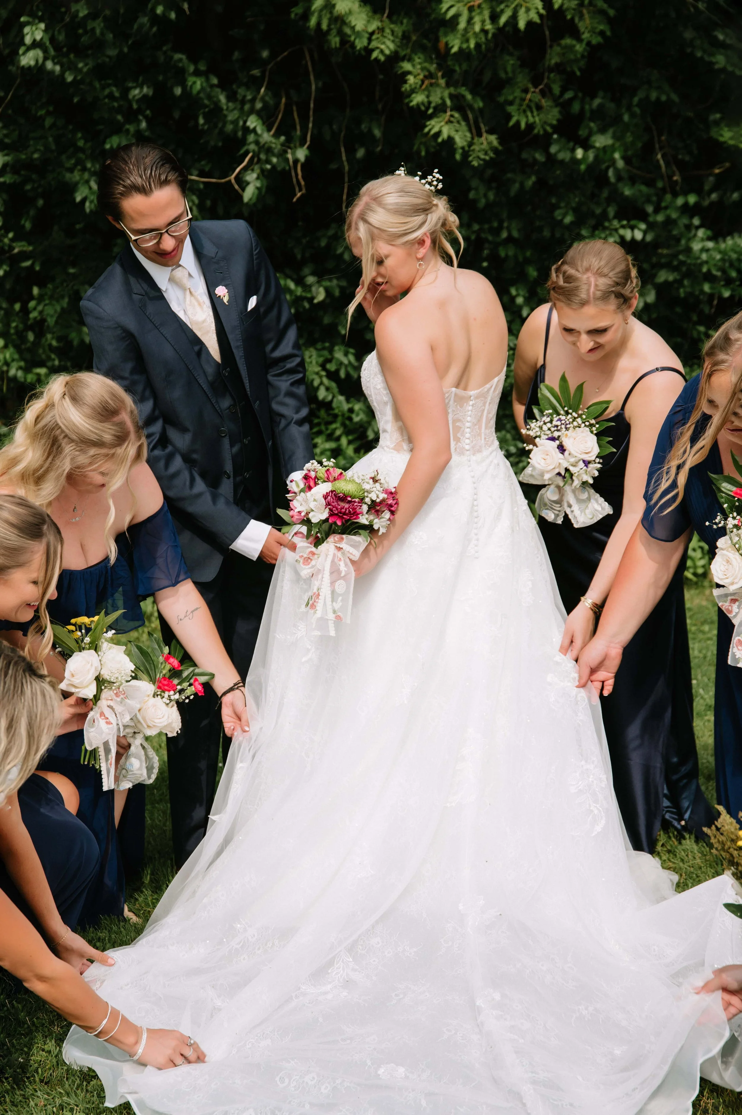 bridal party fixing brides dress.jpg
