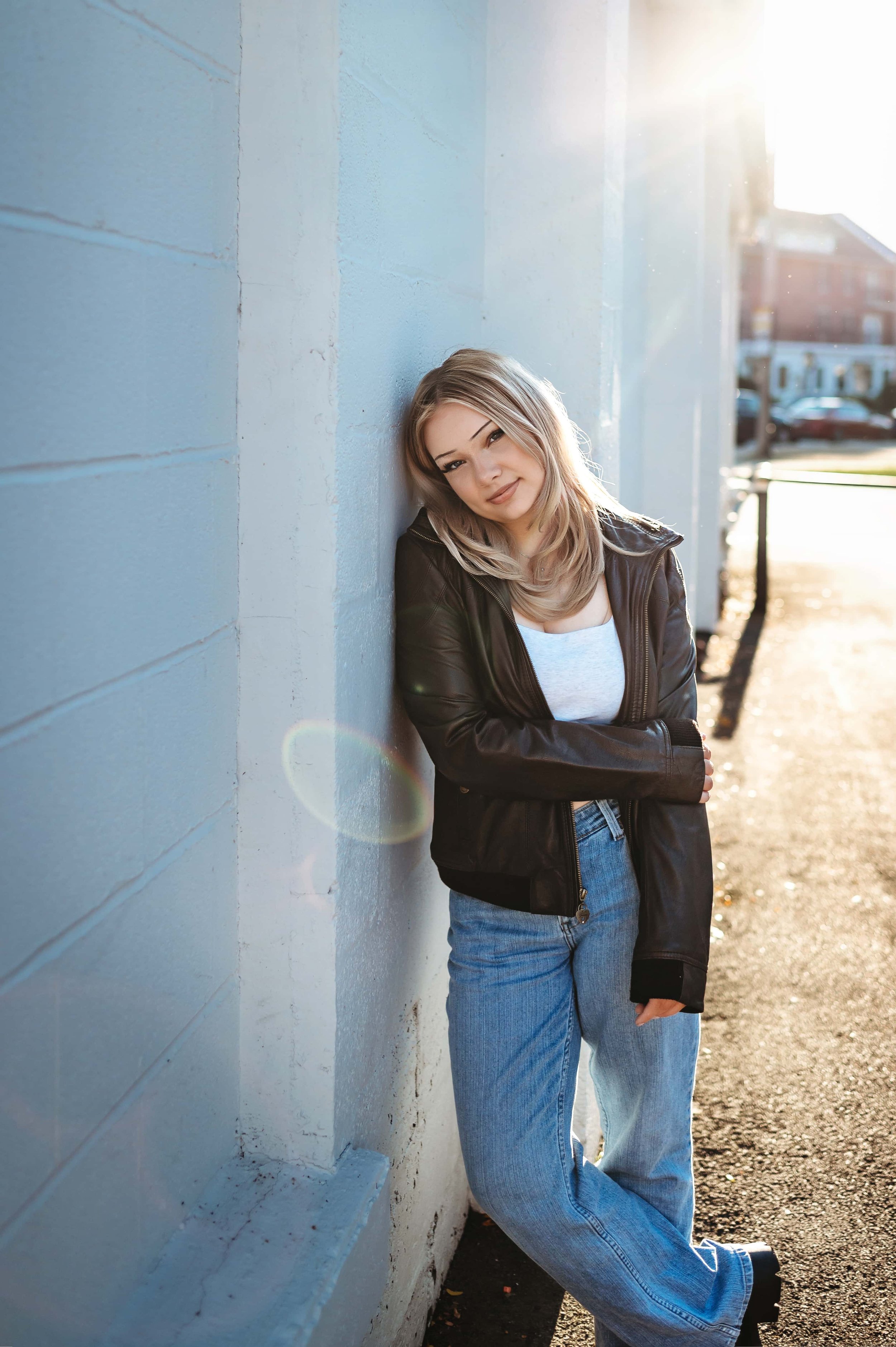 senior girl standing against a wall