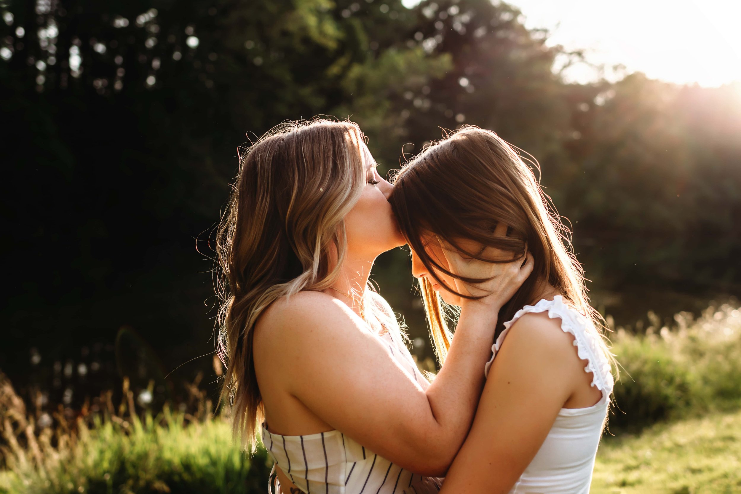 mother kissing older child's forehead