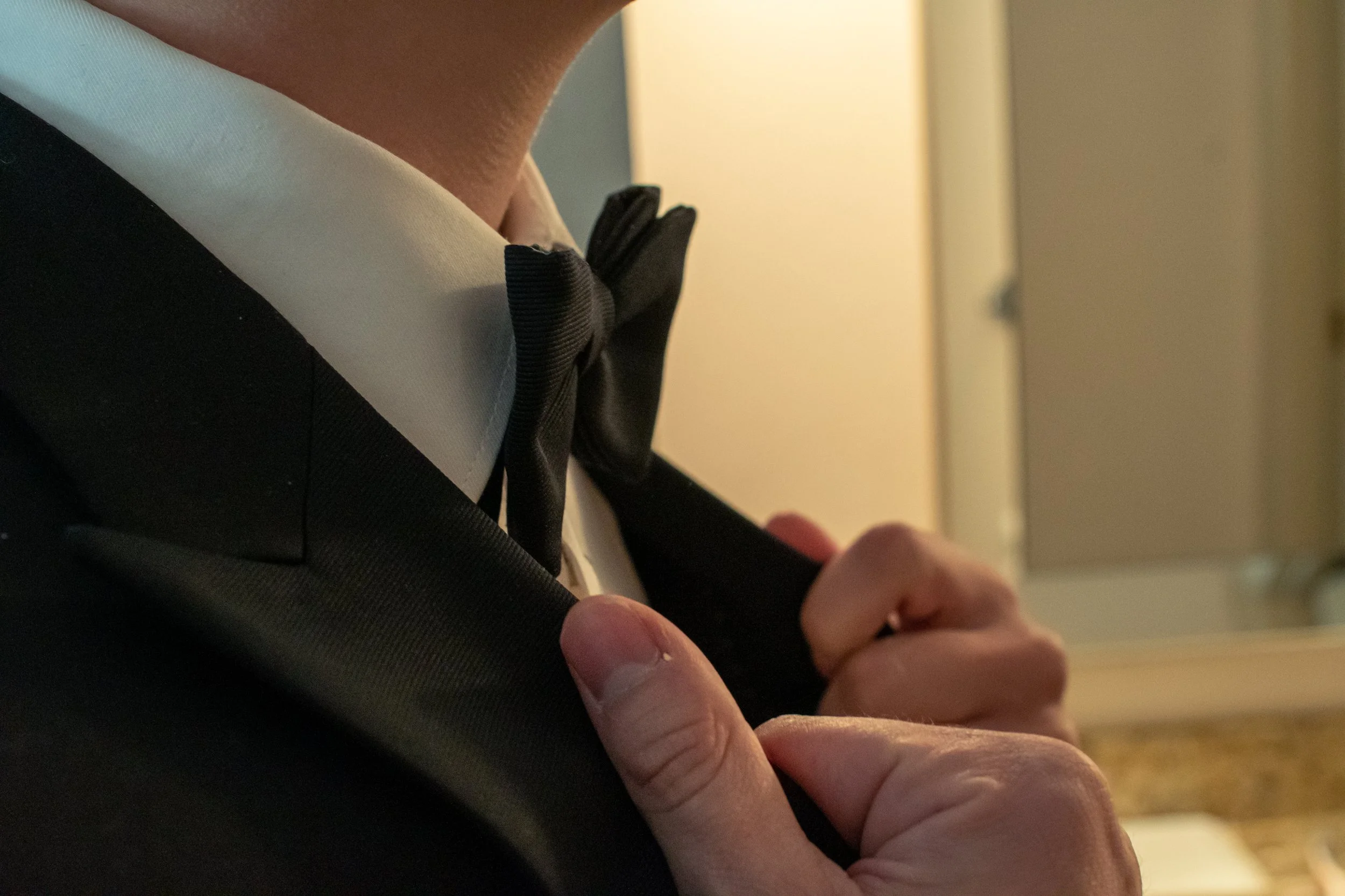 A groom perfects his bowtie, embodying classic style and confidence as he prepares for this unforgettable New York wedding day.
Meticulous details, timeless fashion—captured by a top USA wedding photographer.