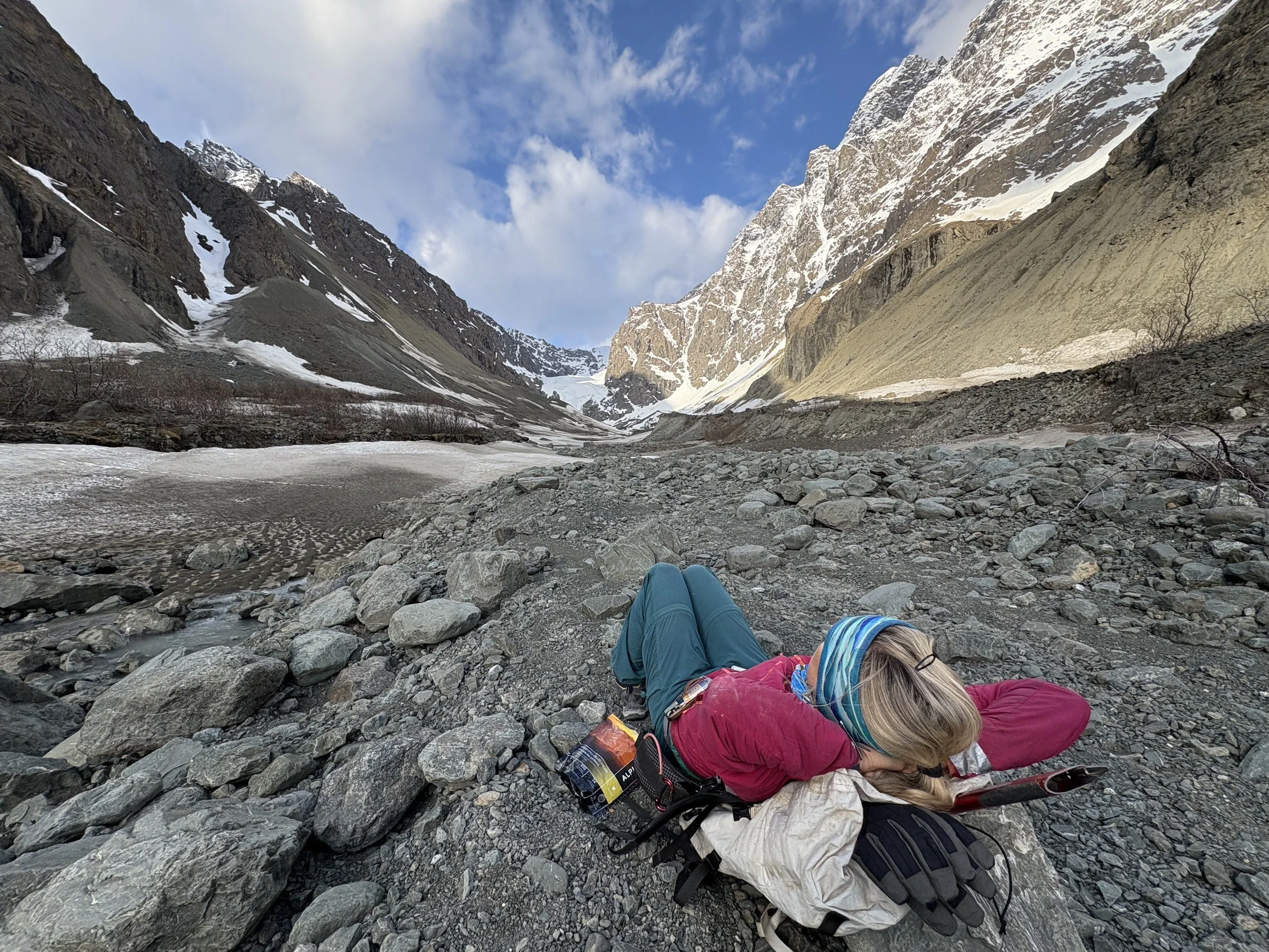 Women mountain climber lays in the rocks taking a nap.