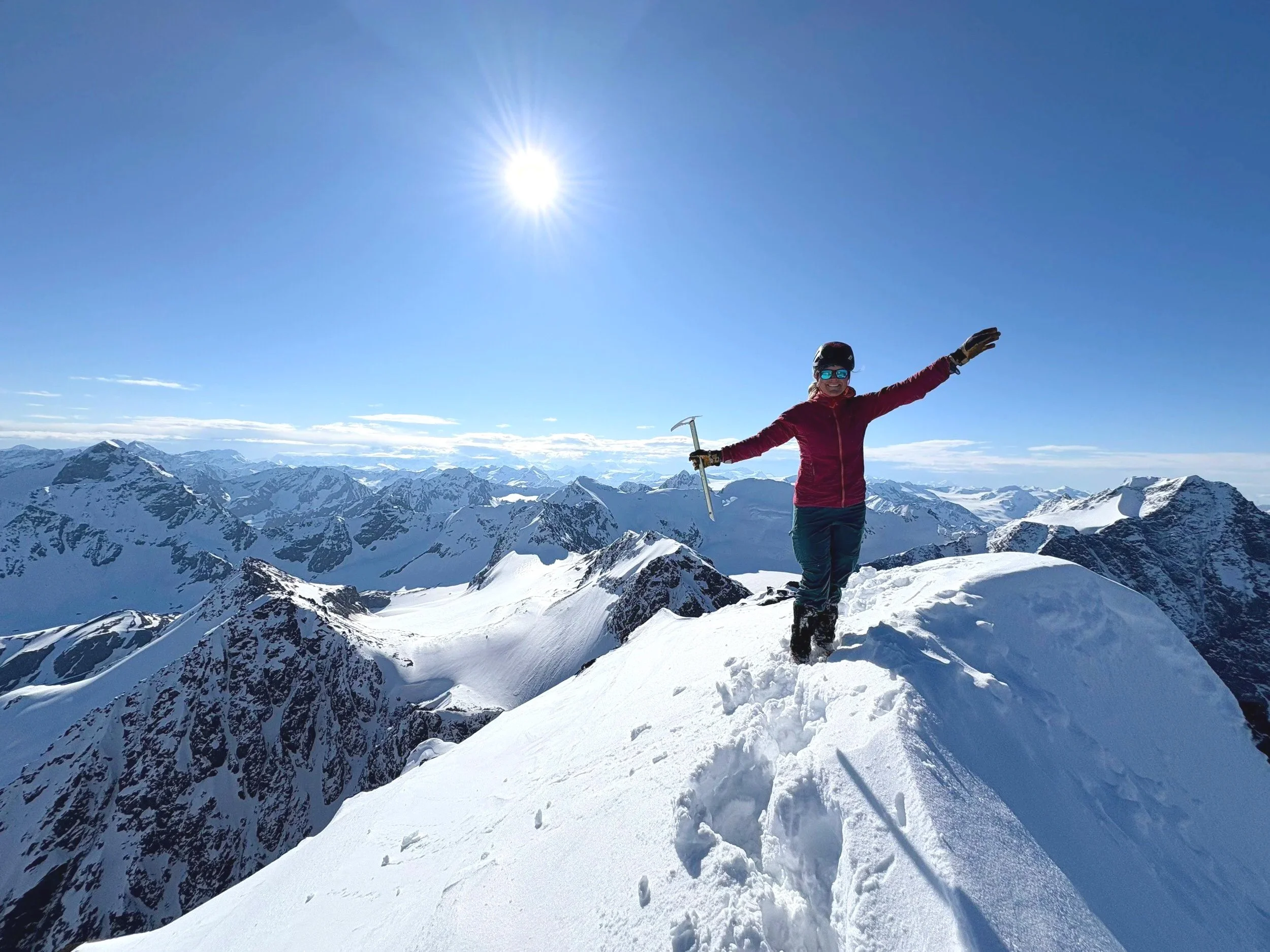 Female stands on the top of West KIliak in the Chugach Mountains.