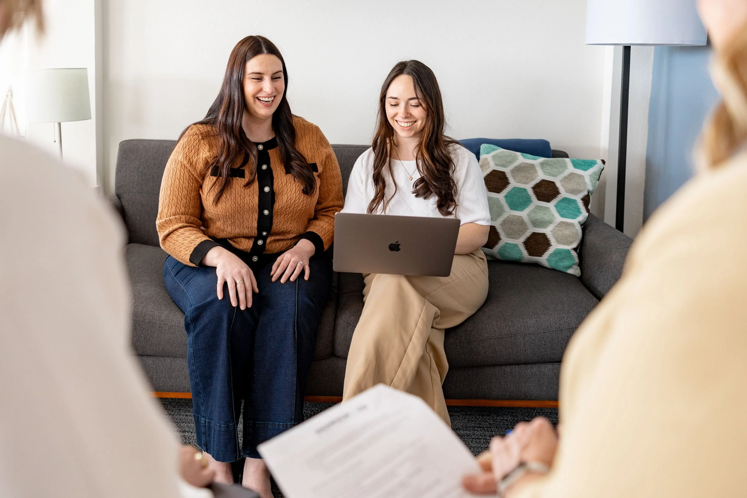 Women marketers work on a computer together.