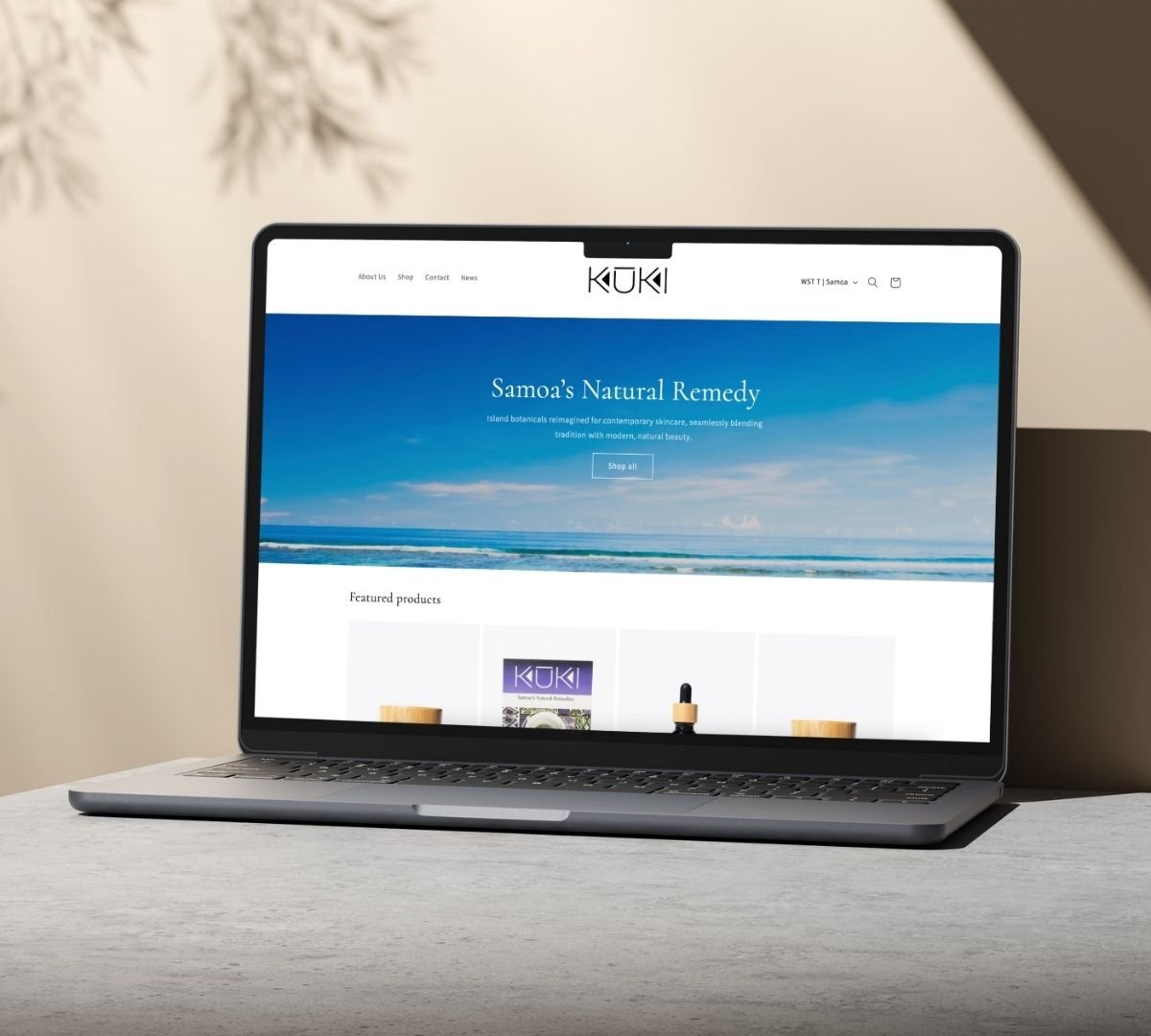 Laptop displaying a website with a blue ocean background, featuring the text "Samoa's Natural Remedy" and navigation links. The site offers skincare products.