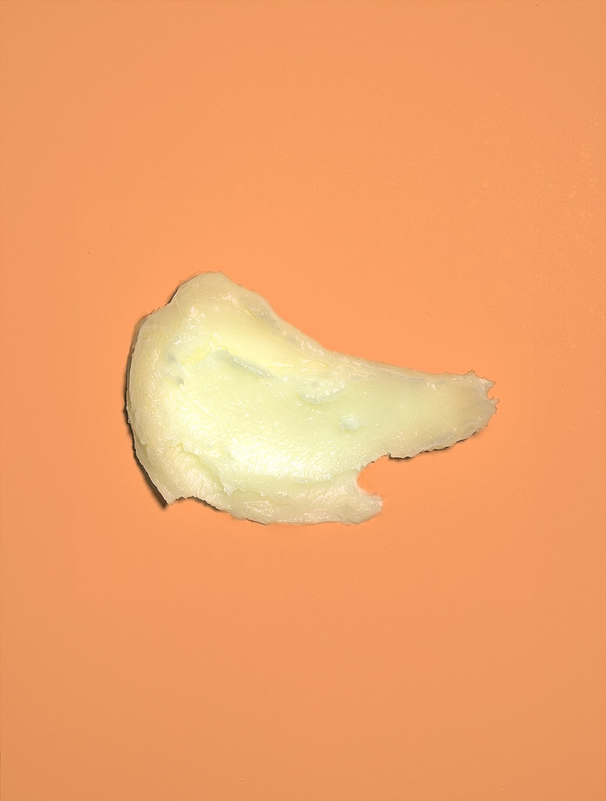 A small dollop of creamy substance on an orange background