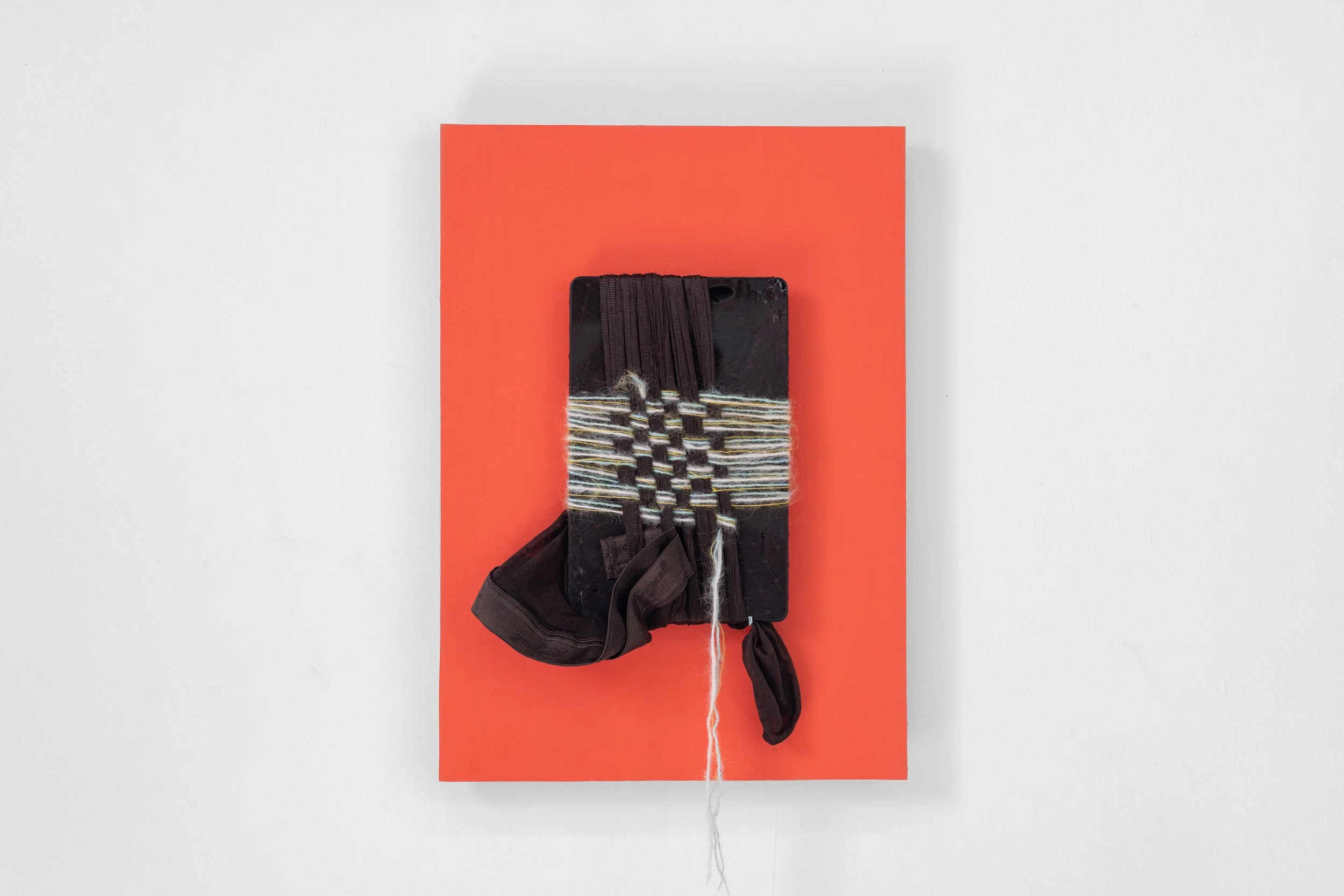 'Relic with Yoyo's tights no.2', 2026, ribbon, tights, broken iPad, hand-dyed paper mounted on board, 42 x 29.5 x 3 cm