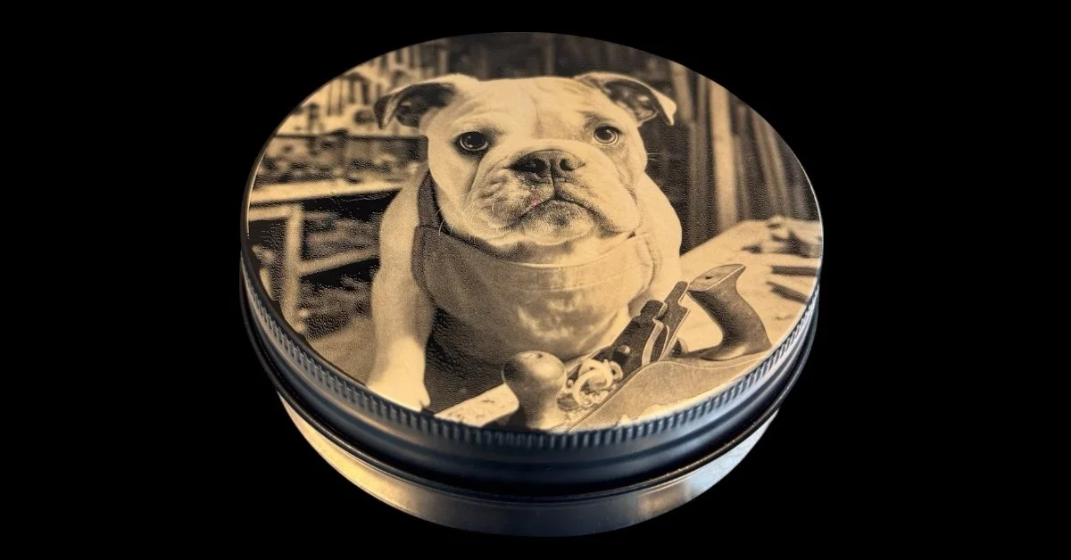 Custom engraved treat tin featuring a photo of a bulldog puppy, sitting in a workshop with woodworking tools, printed on a round container lid.