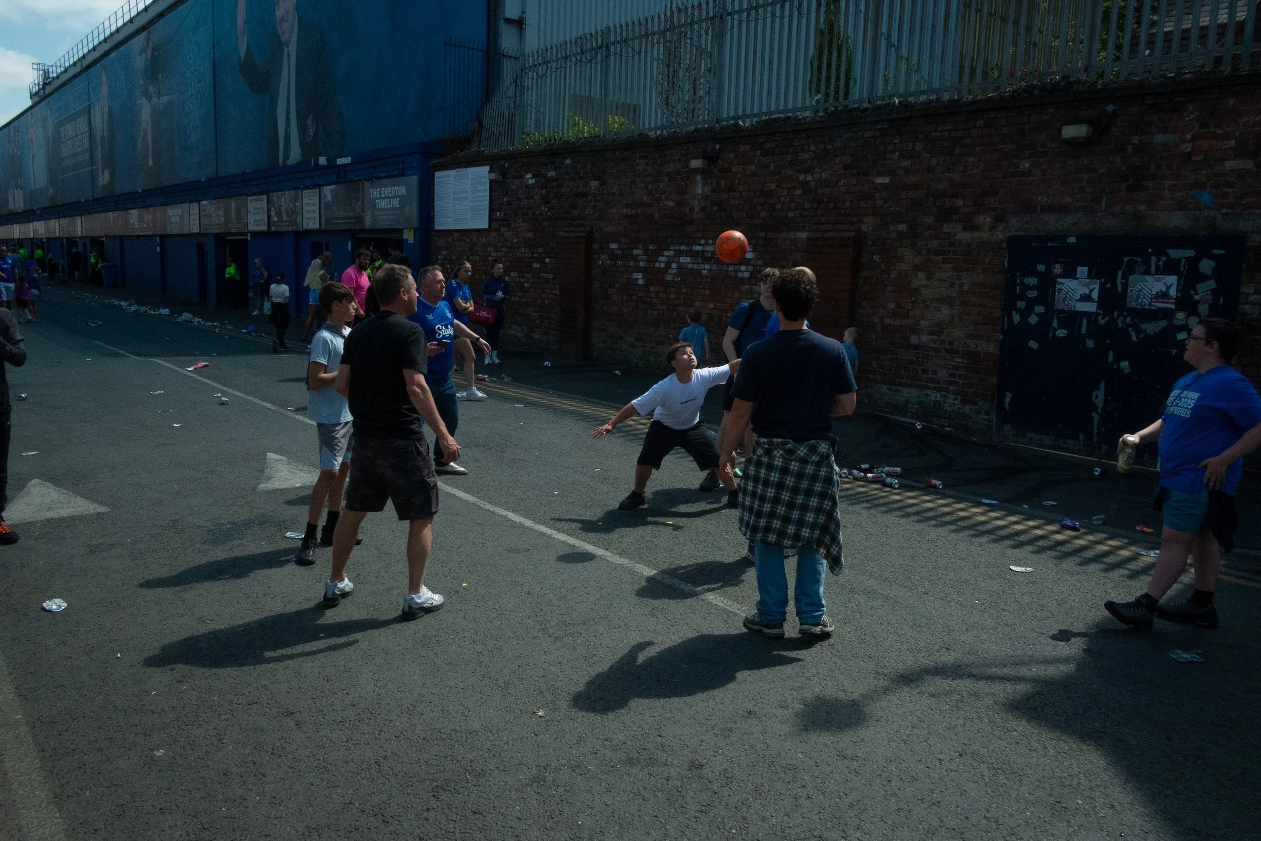 People playing a street game with a basketball in an urban alleyway.