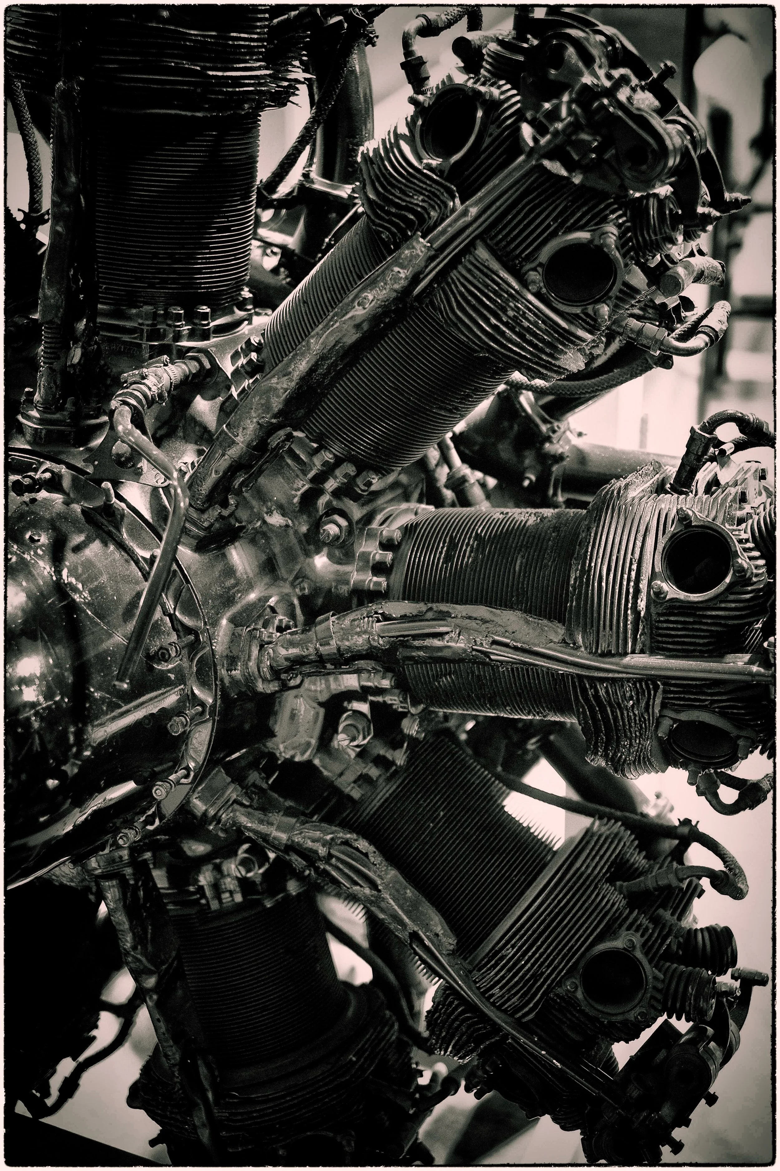Close-up of a black motorcycle engine with visible cylinders, pipes, and mechanical parts.