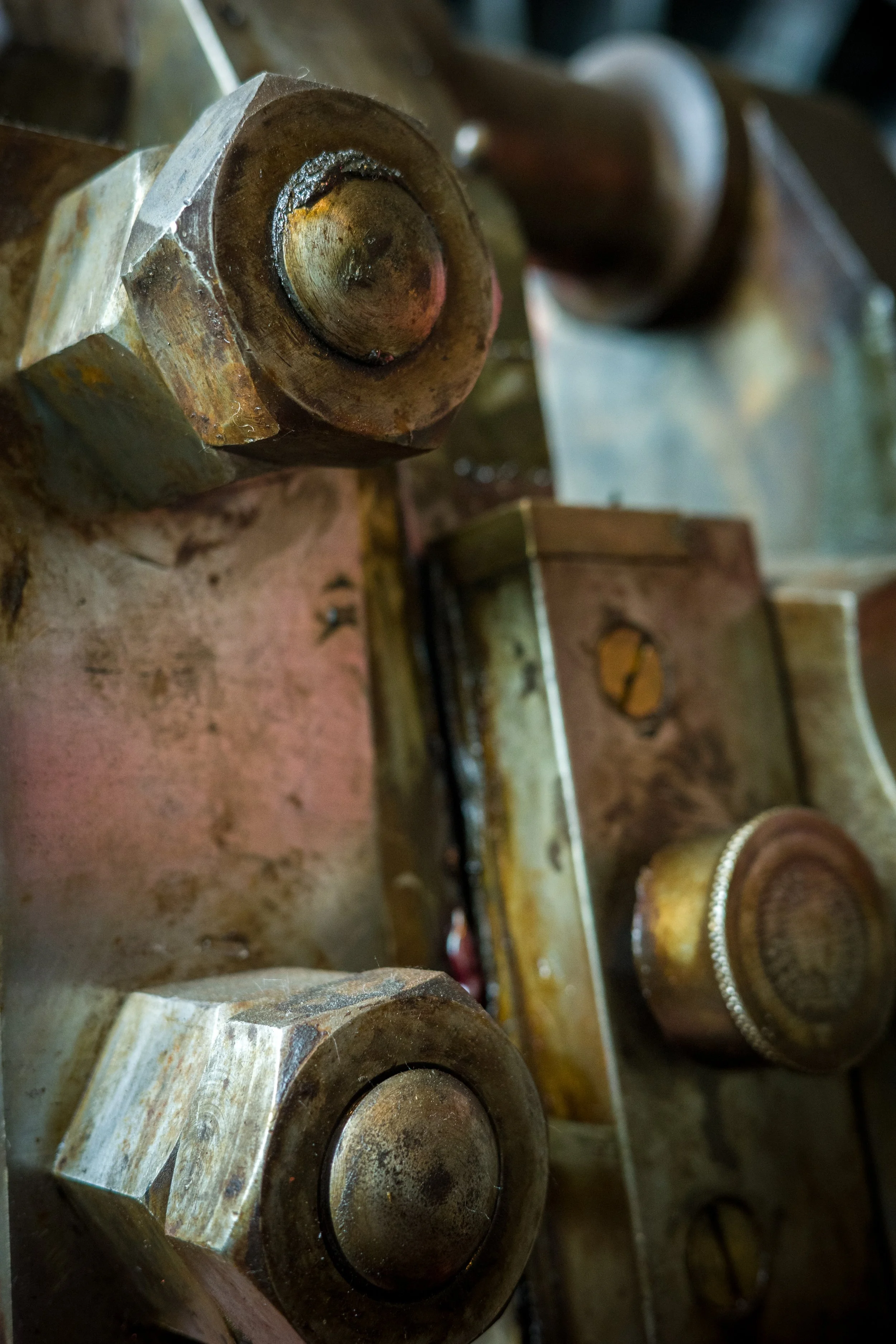 Close-up of large metal industrial bolts arranged in rows on a machinery or structural frame.