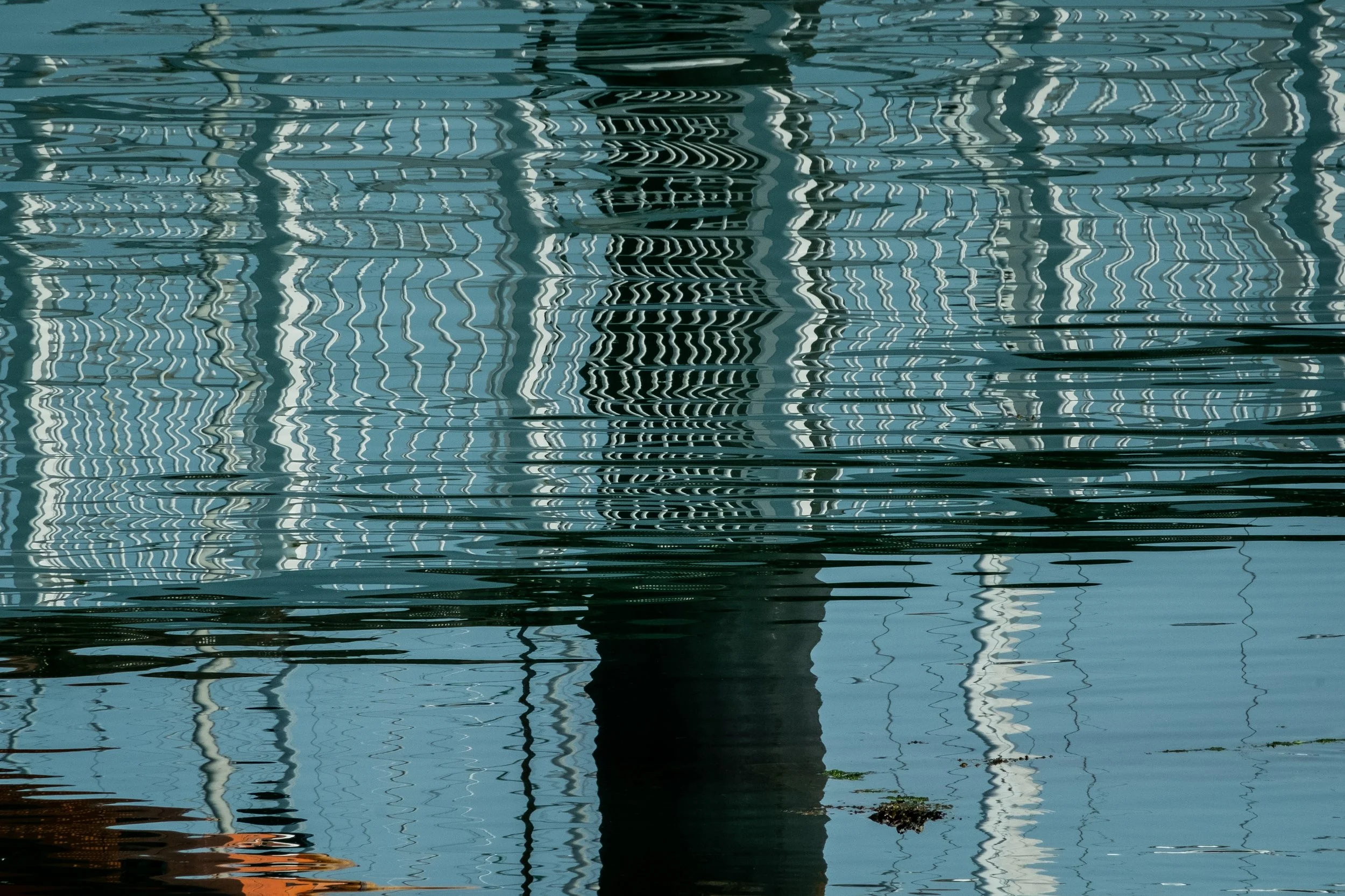 Reflection of building and boats on water with ripples