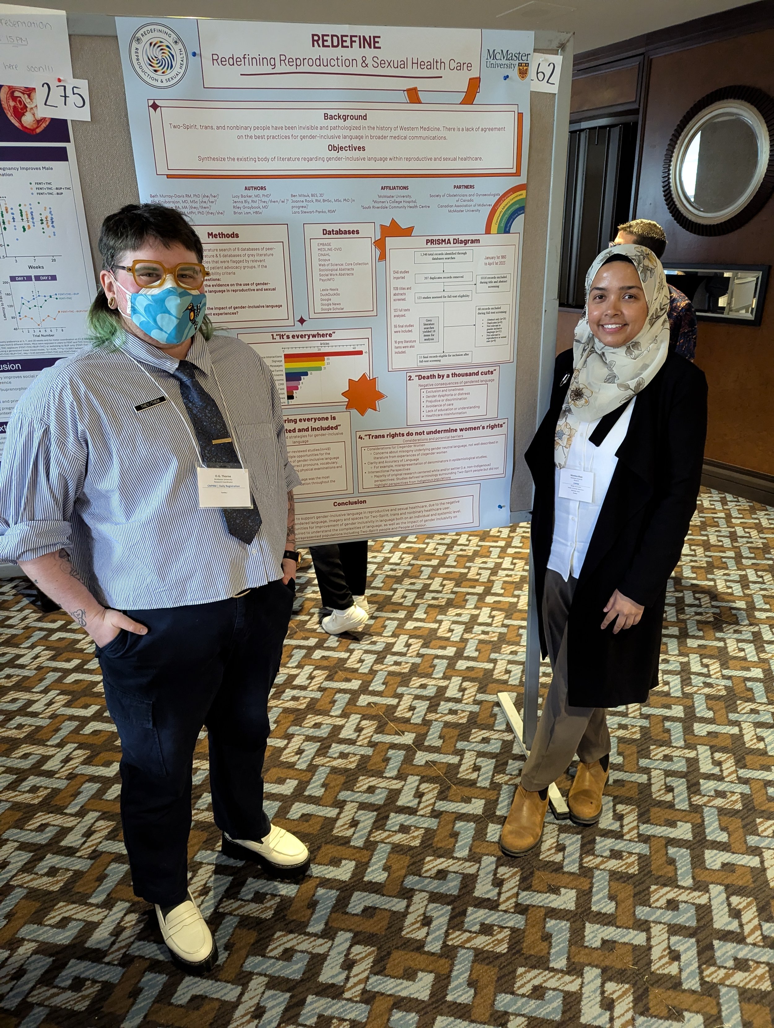 Two people standing in front of a poster presentation about redefining reproductive and sexual health care at a conference.