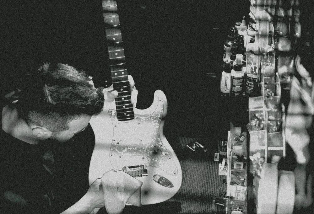 Guitar technician working on an electric guitar in a workshop