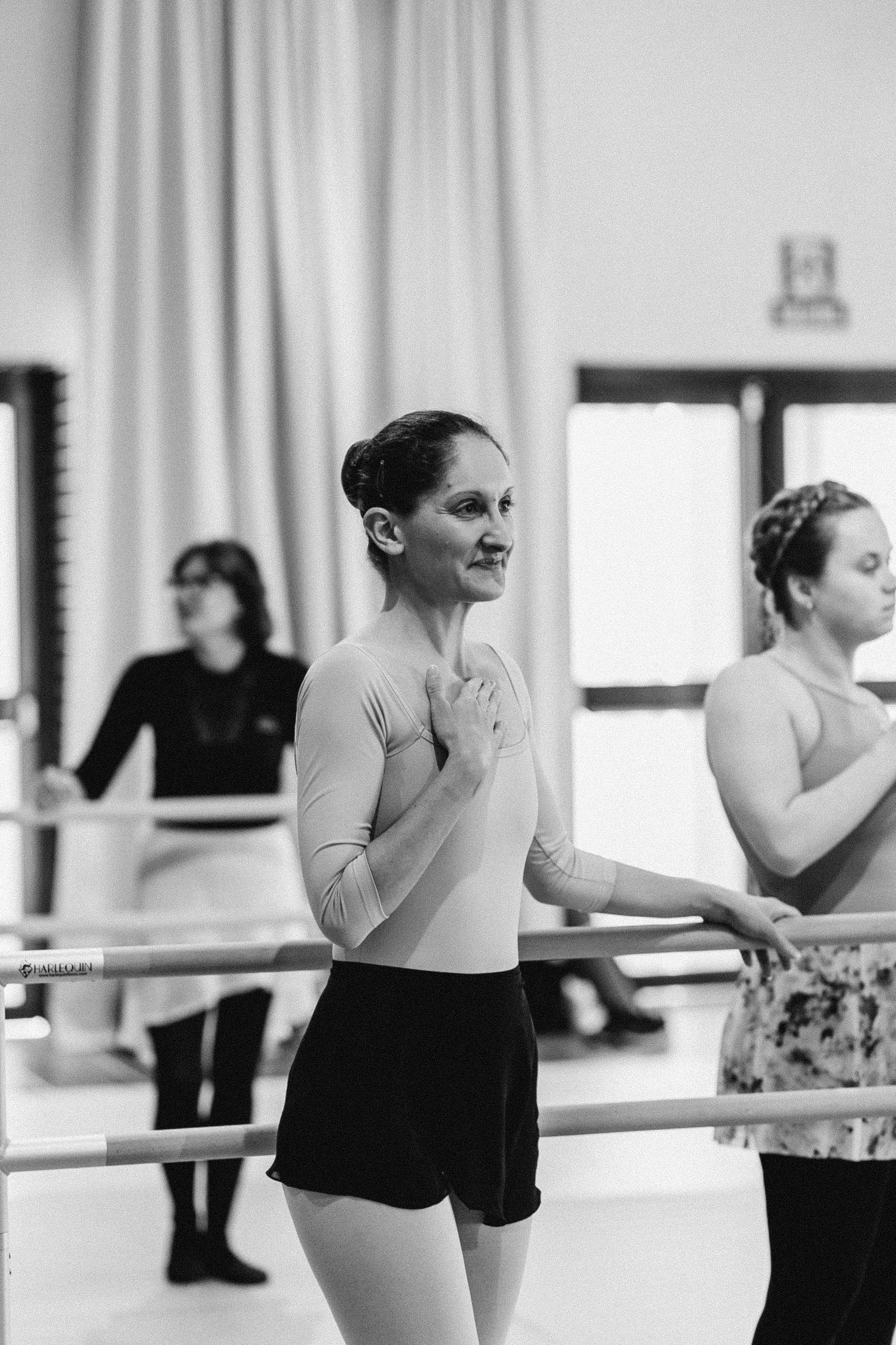 Ballet dancers practicing at a barre in a Norfolk dance studio.