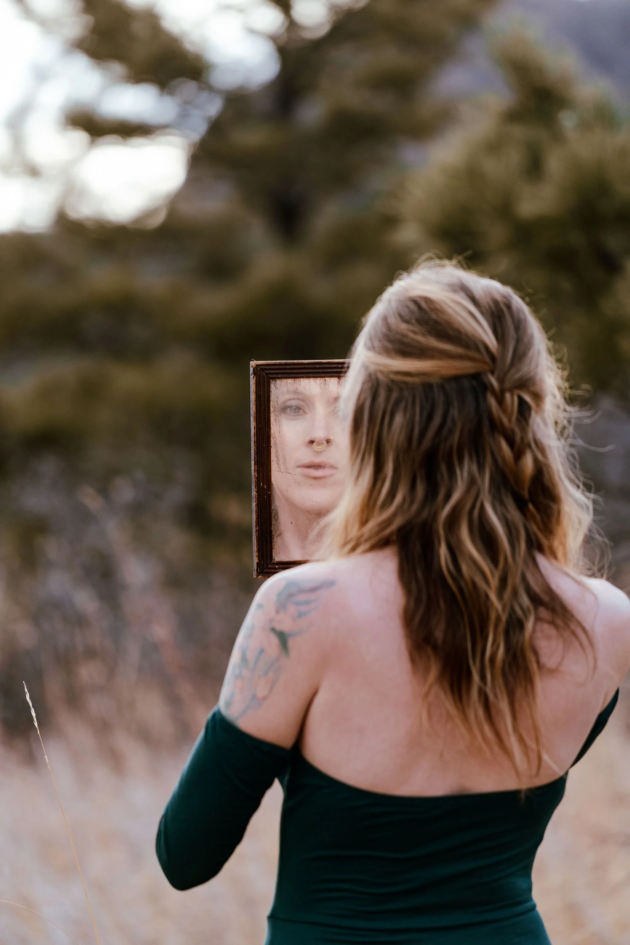 Woman staring at herself with a vintage mirror