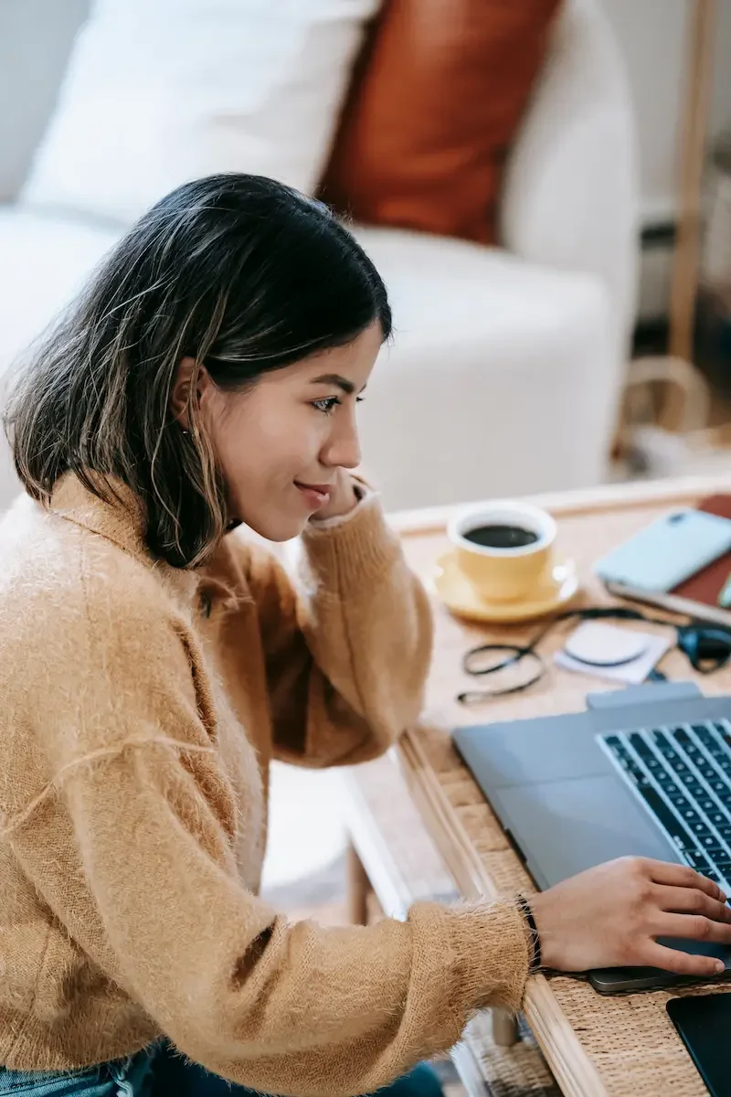 A smiling woman using a laptop