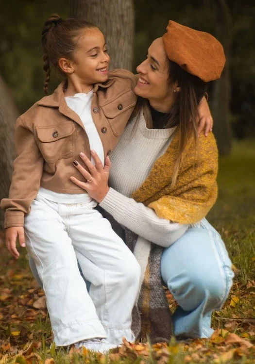 A mom with her daughter, smiling.