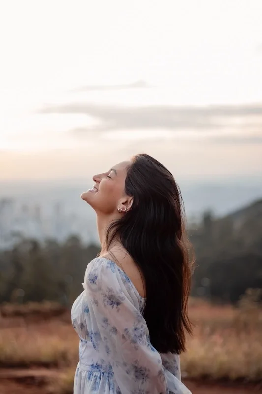 A woman smiling into the sky.