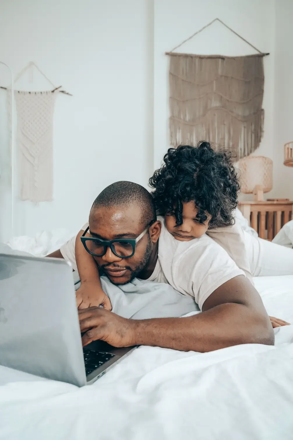 Father with kid on his back using a laptop